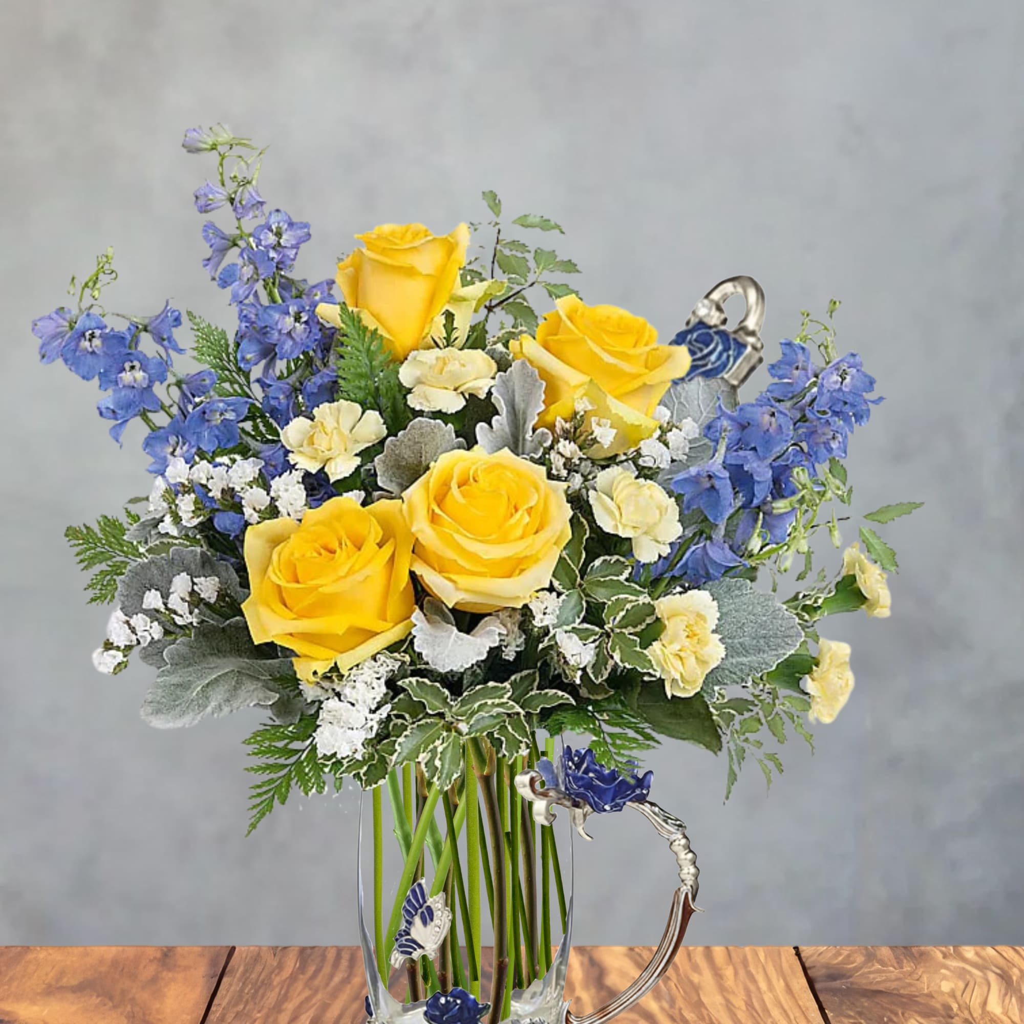 Bright yellow roses form the sunny heart of this flower arrangement, making
