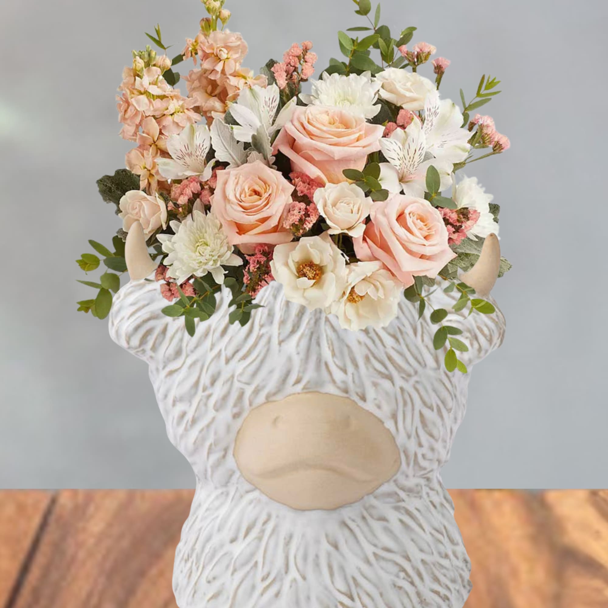 Soft peach roses and blush blooms gathered in a compact, rounded bouquet