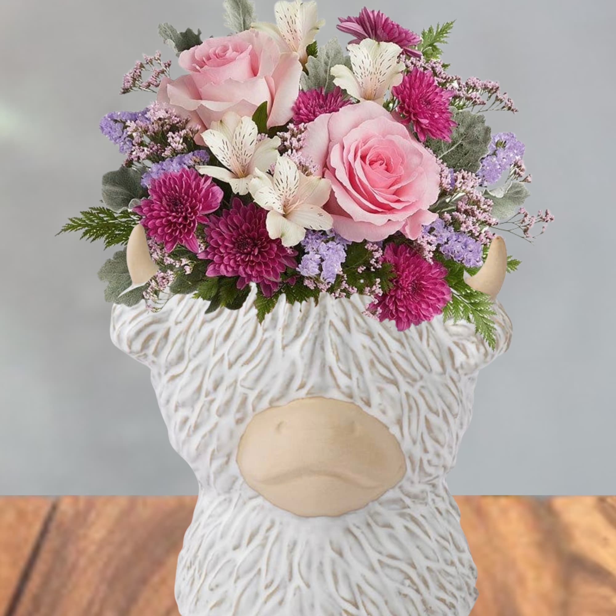 Soft pink roses and bright magenta chrysanthemums give this flower arrangement a