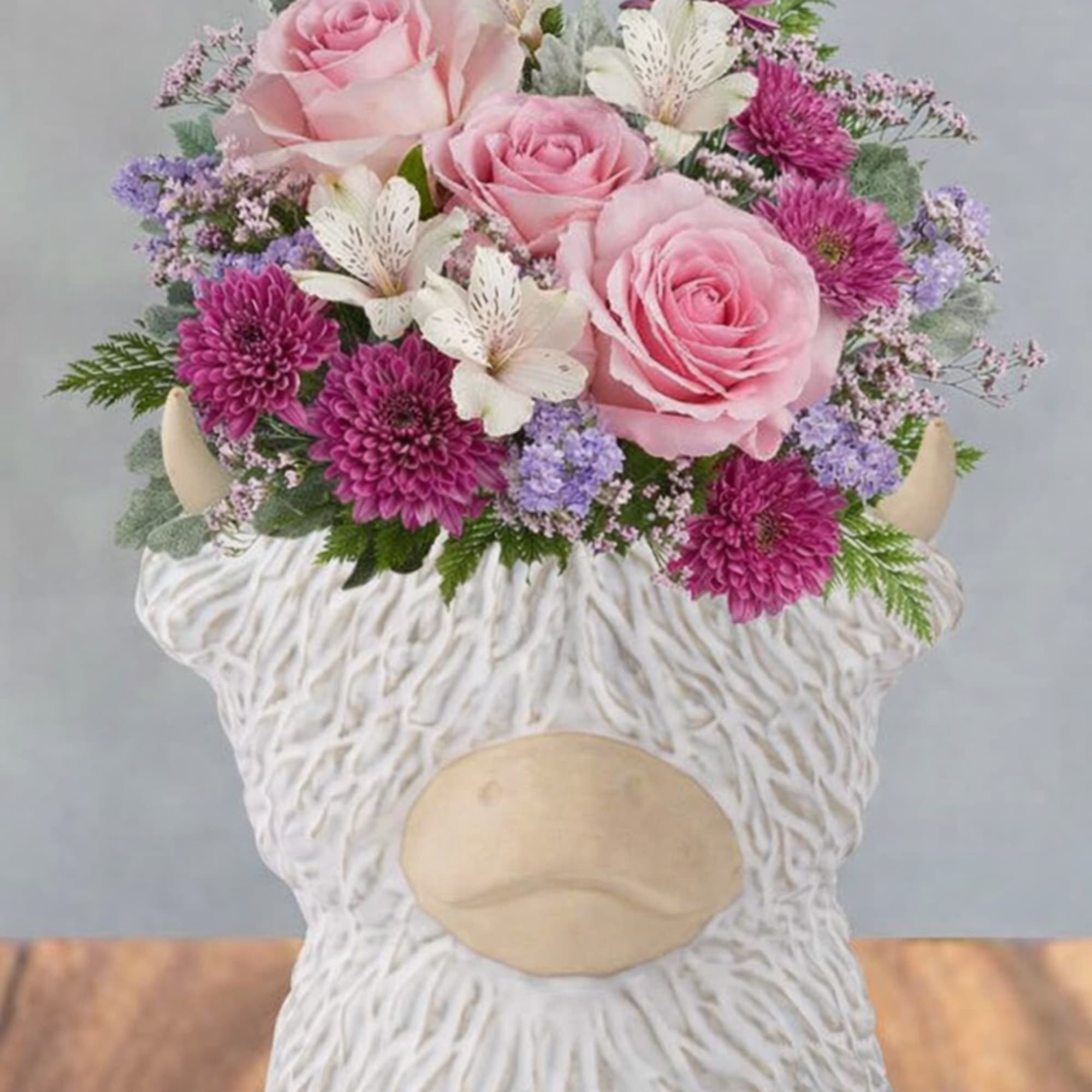 Soft pink roses and bright magenta chrysanthemums give this flower arrangement a