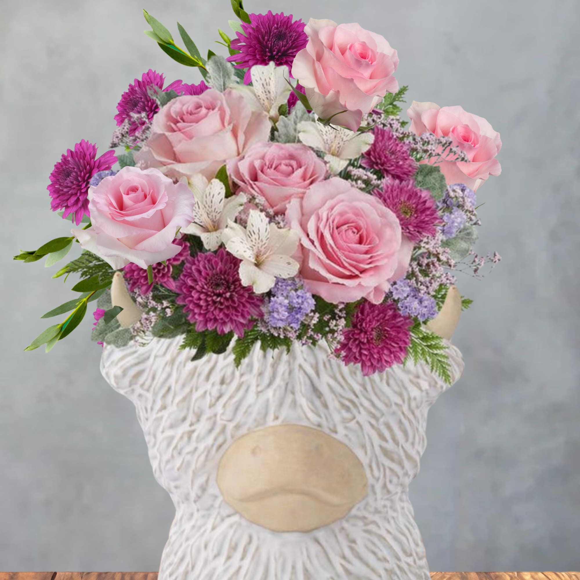Soft pink roses and bright magenta chrysanthemums give this flower arrangement a