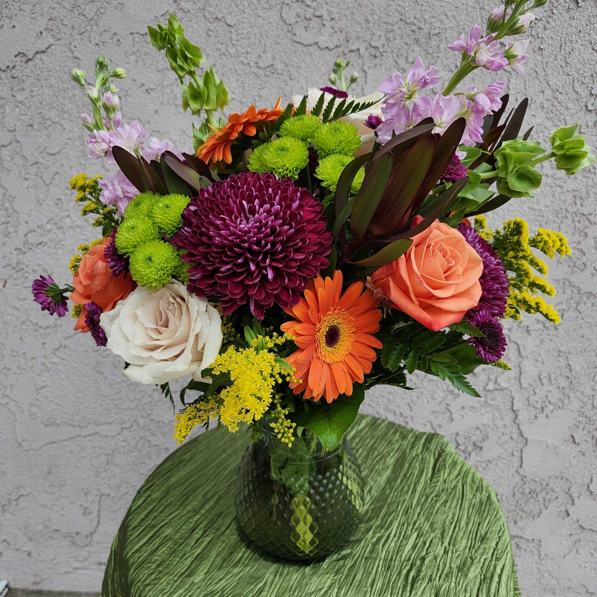 Fall colors of various flowers for this full all around vase bouquet.