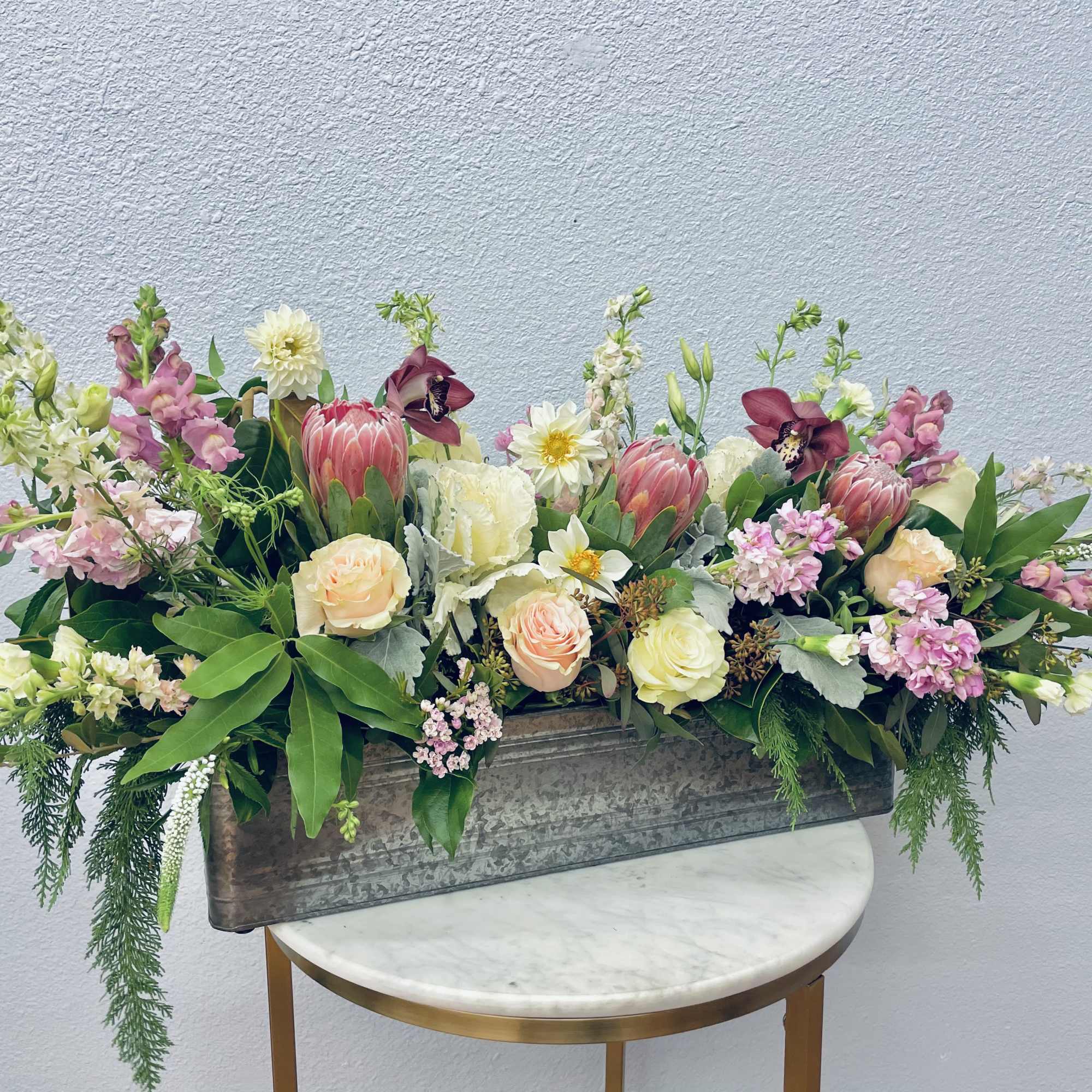 Mixed floral arrangement in a rectangular metal planter