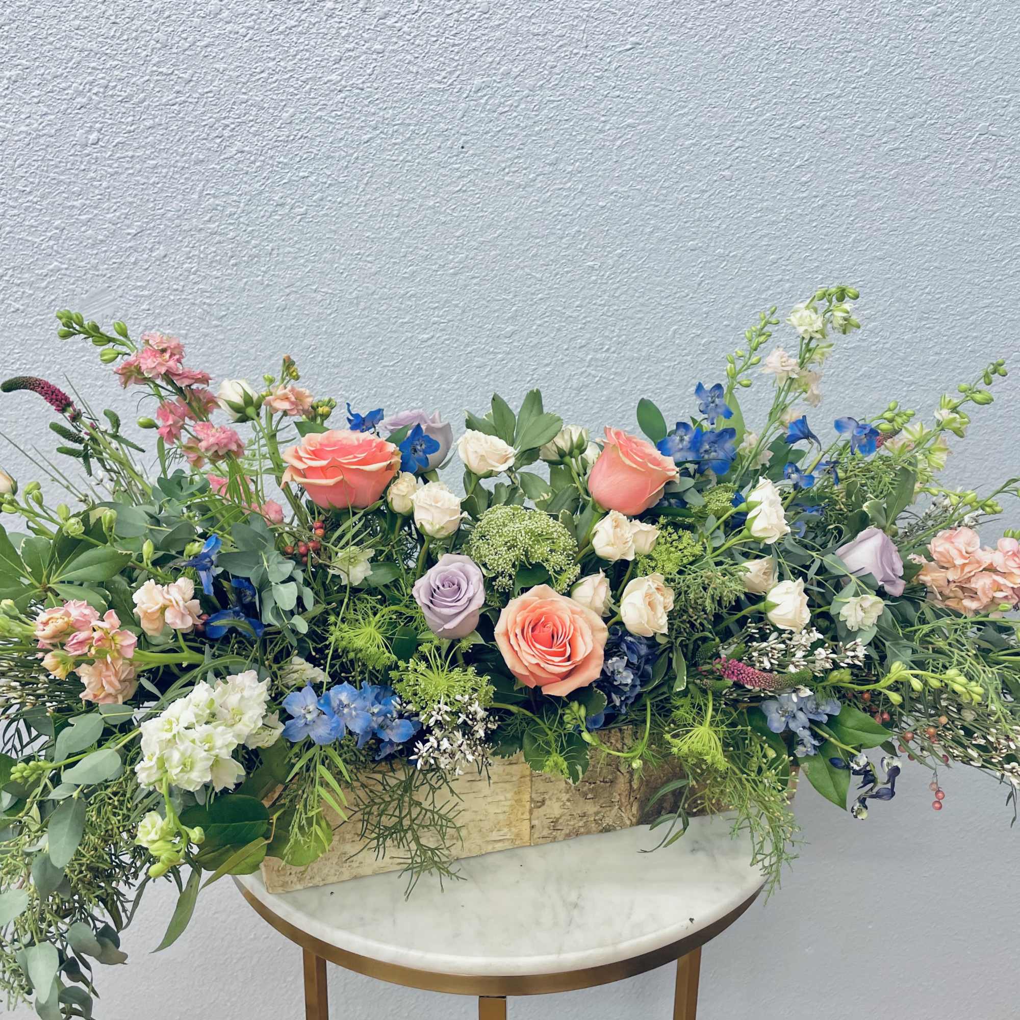 Large mixed floral arrangement in a rectangular wooden container