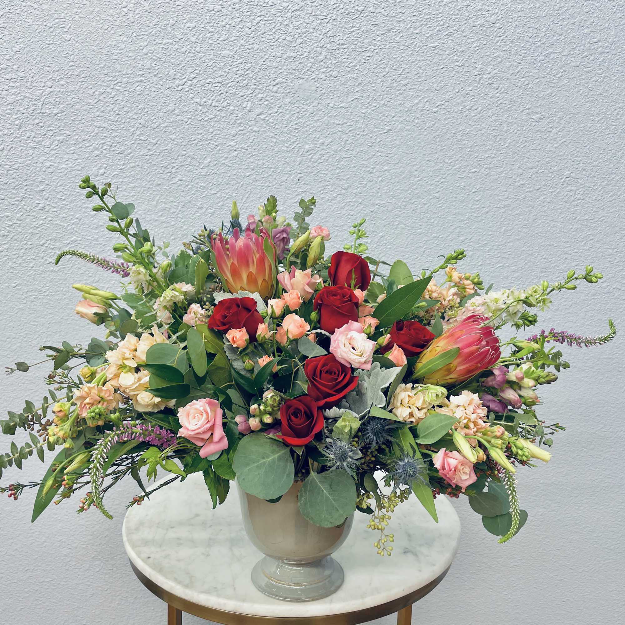 Large mixed bouquet of red and pink roses in a glass vase