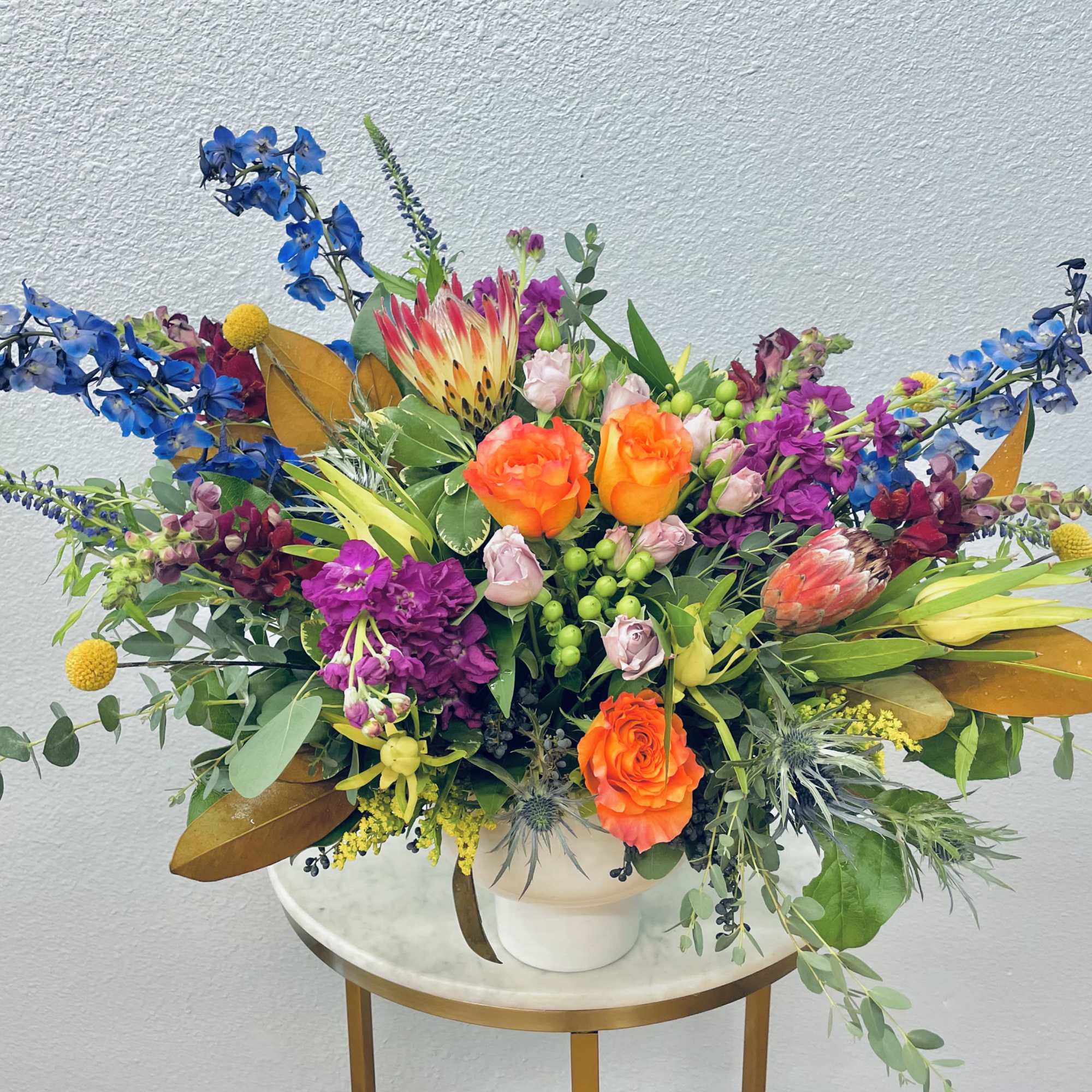 Large colorful floral arrangement in a white vase
