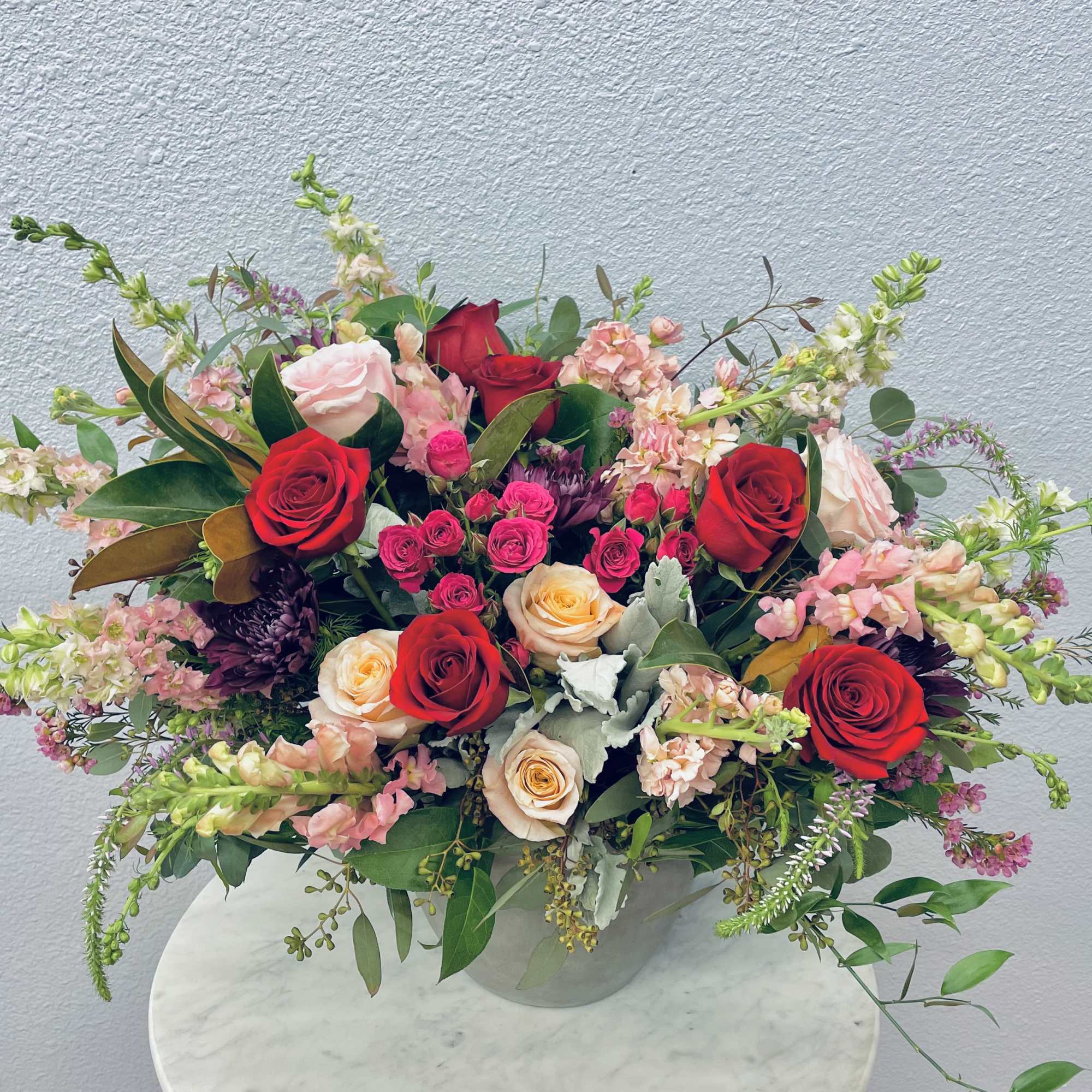 Mixed bouquet of red and blush roses in a clear vase