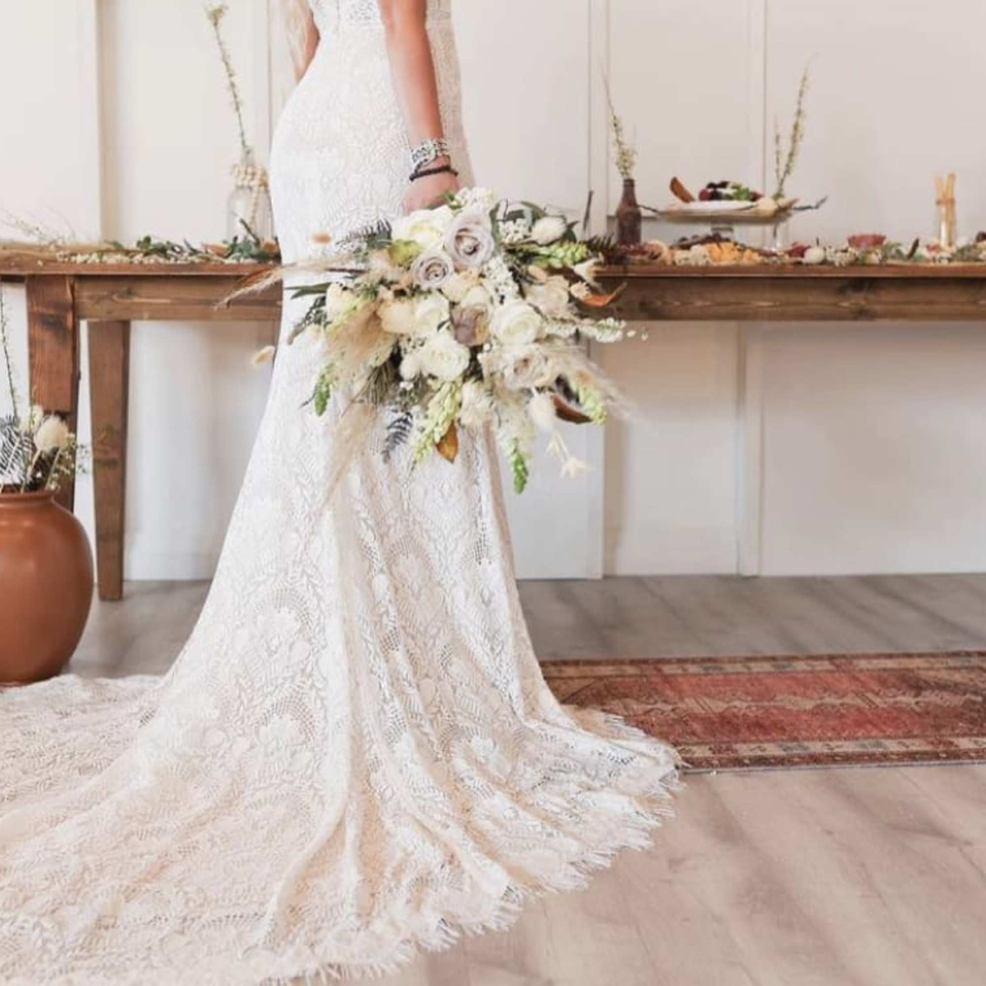 Bride holding a cascading bouquet of pale roses and white flowers