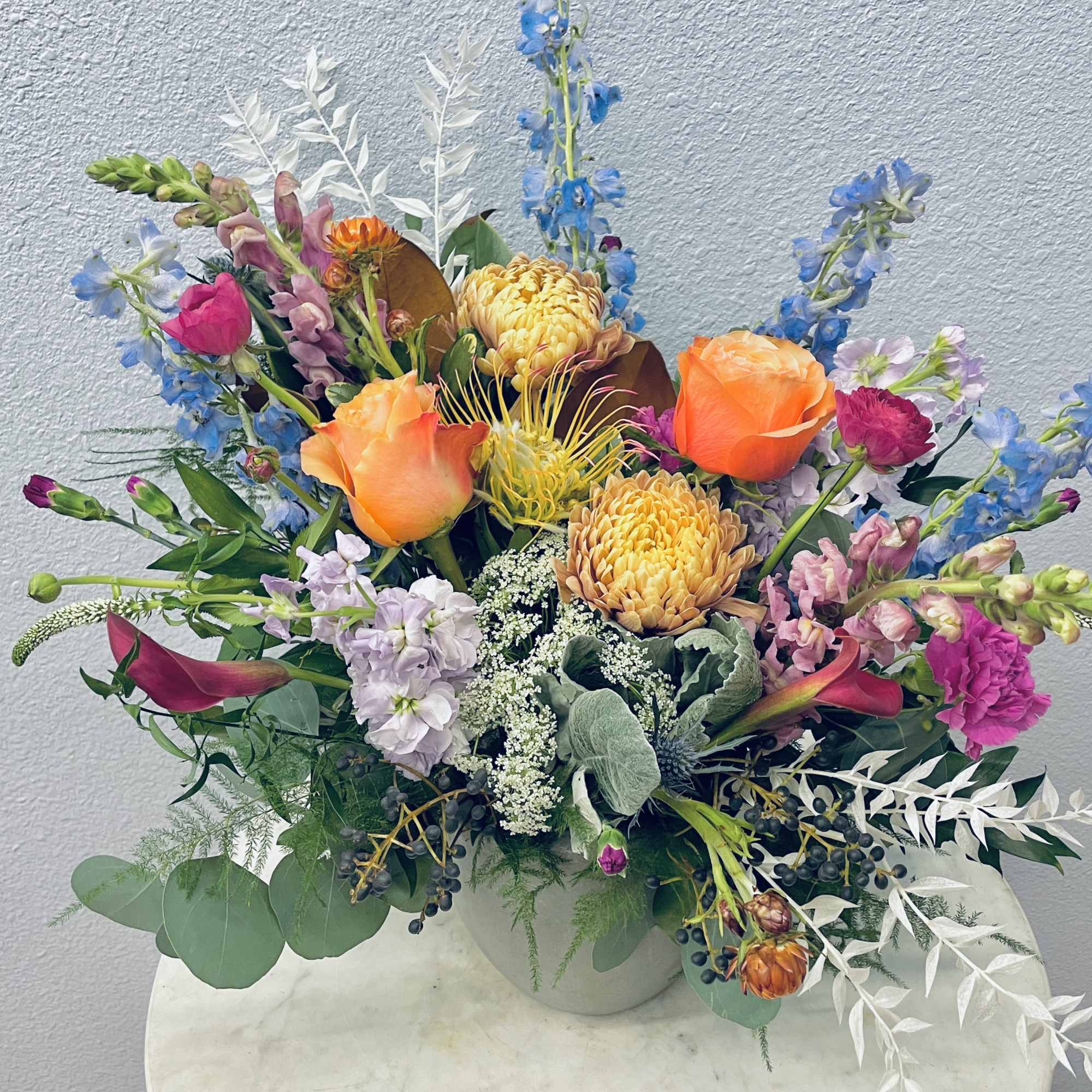 Colorful mixed flower arrangement in a white vase