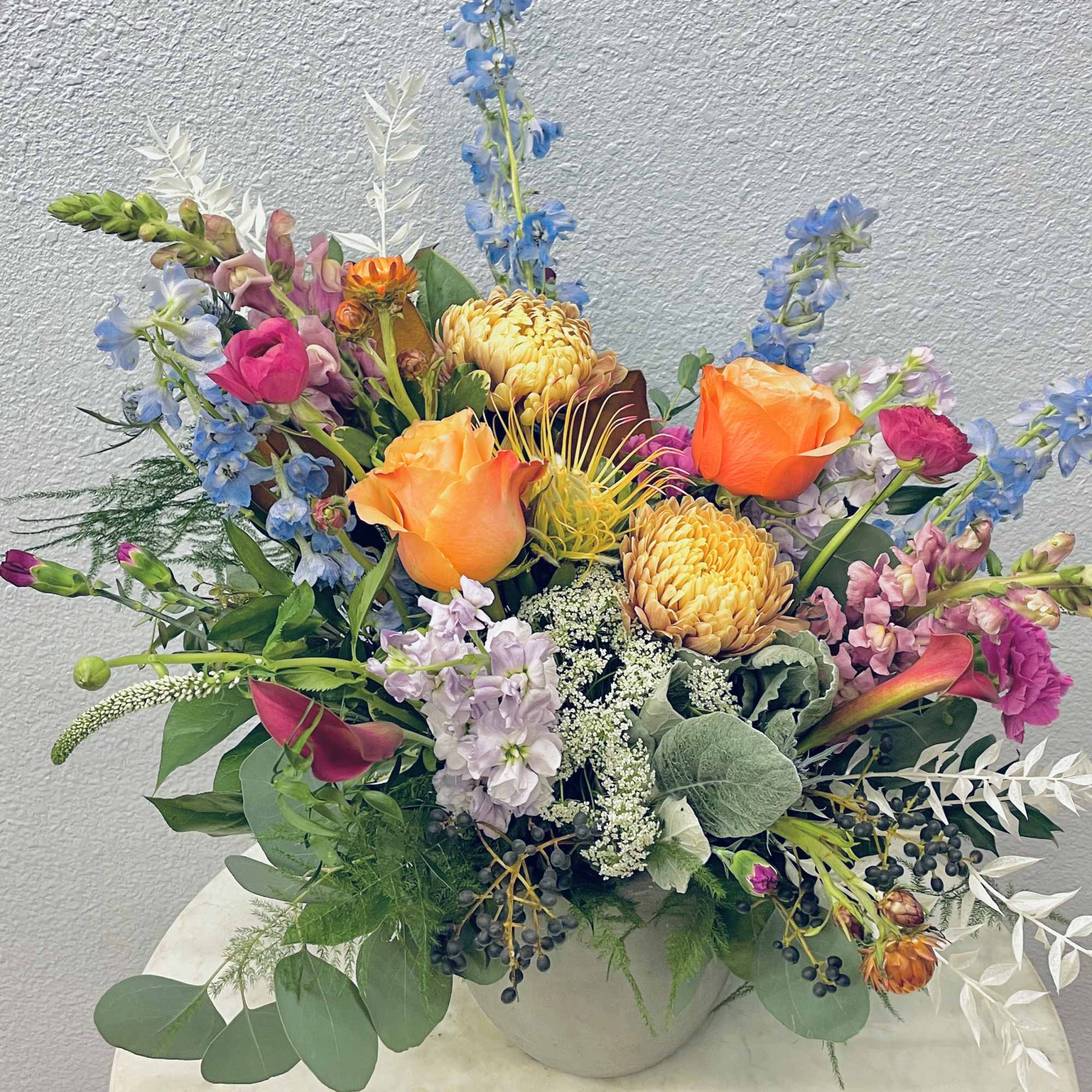 Colorful mixed flower arrangement in a white vase, photo 2 of 3