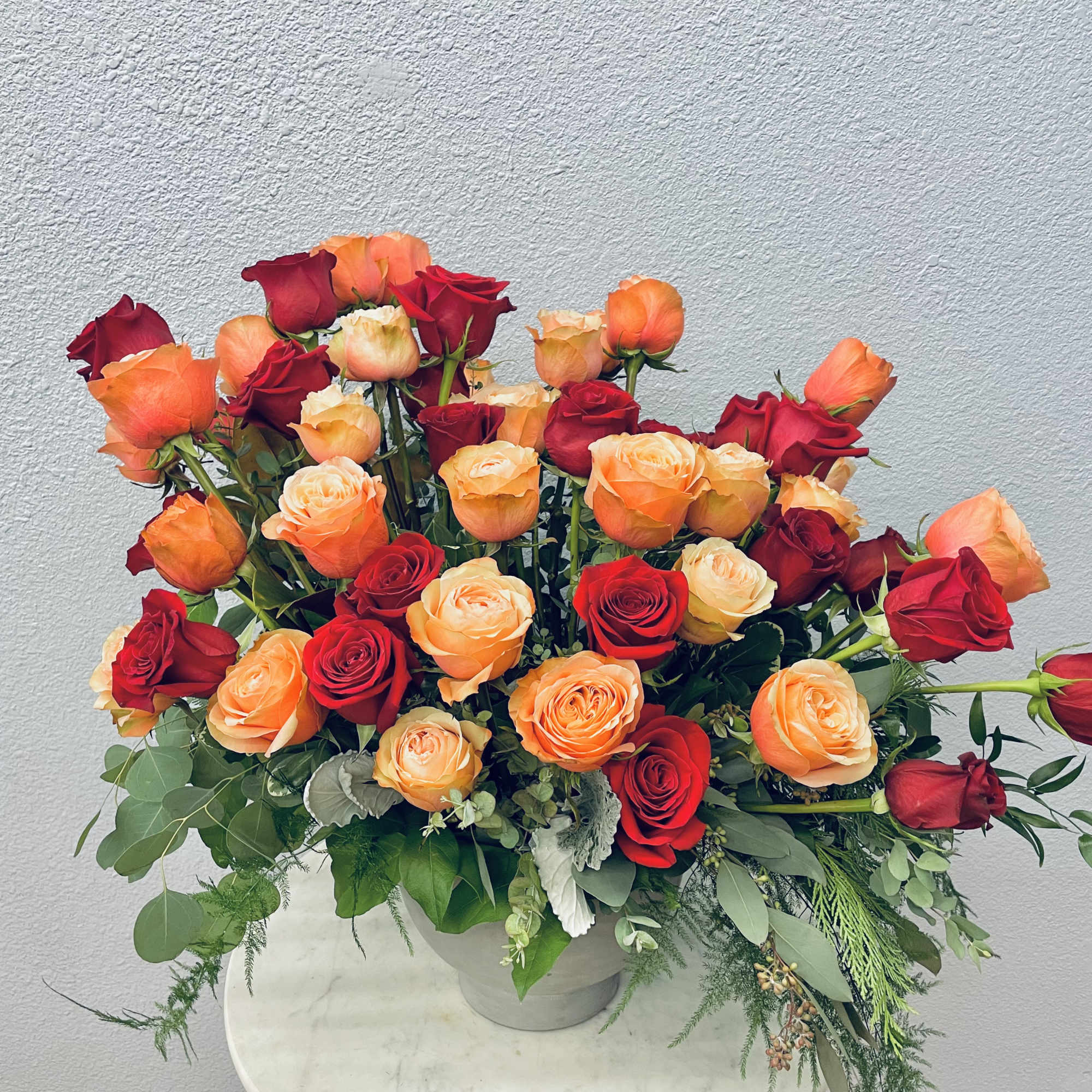 Large bouquet of red and orange roses in a vase