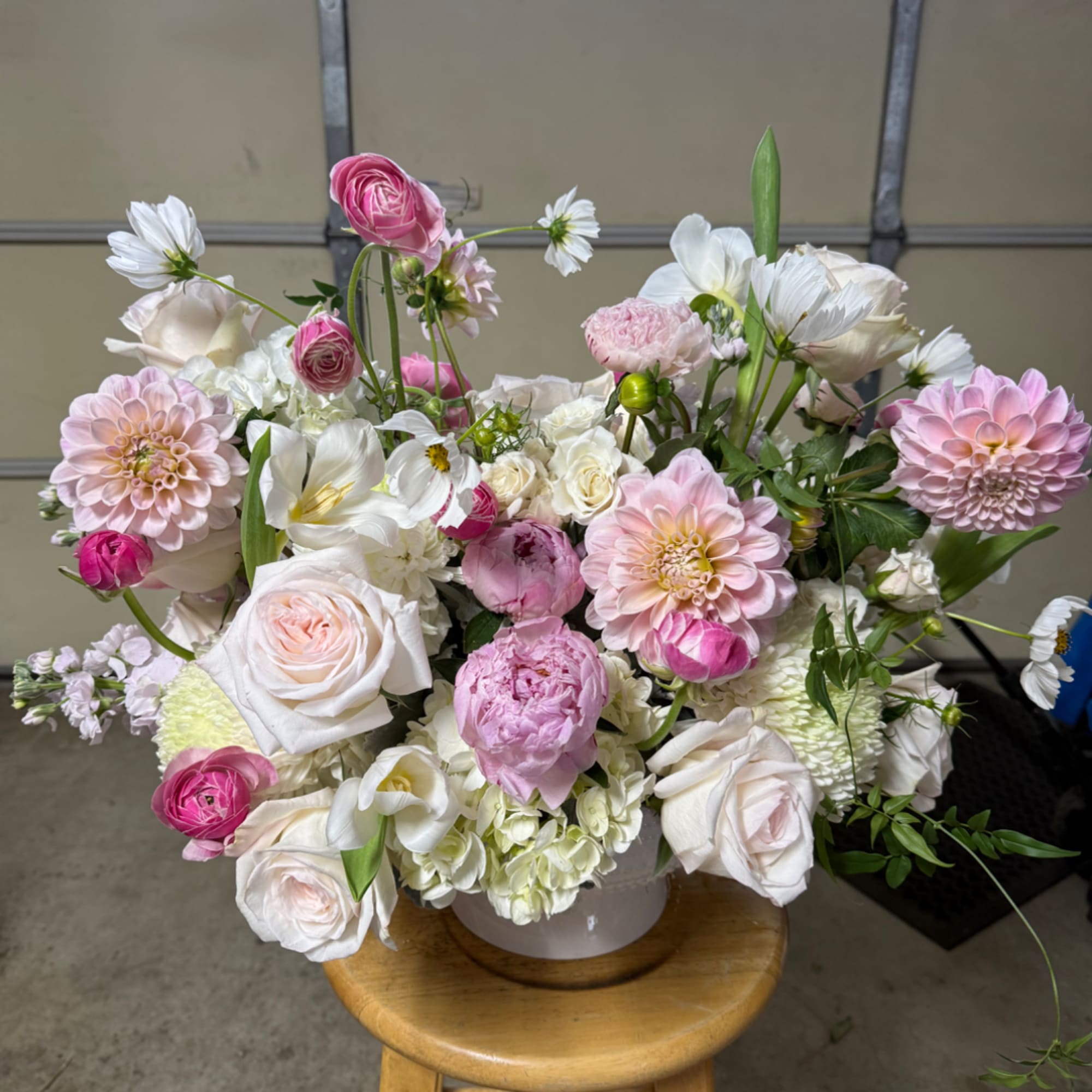 Mixed pink and white flower arrangement in a white vase