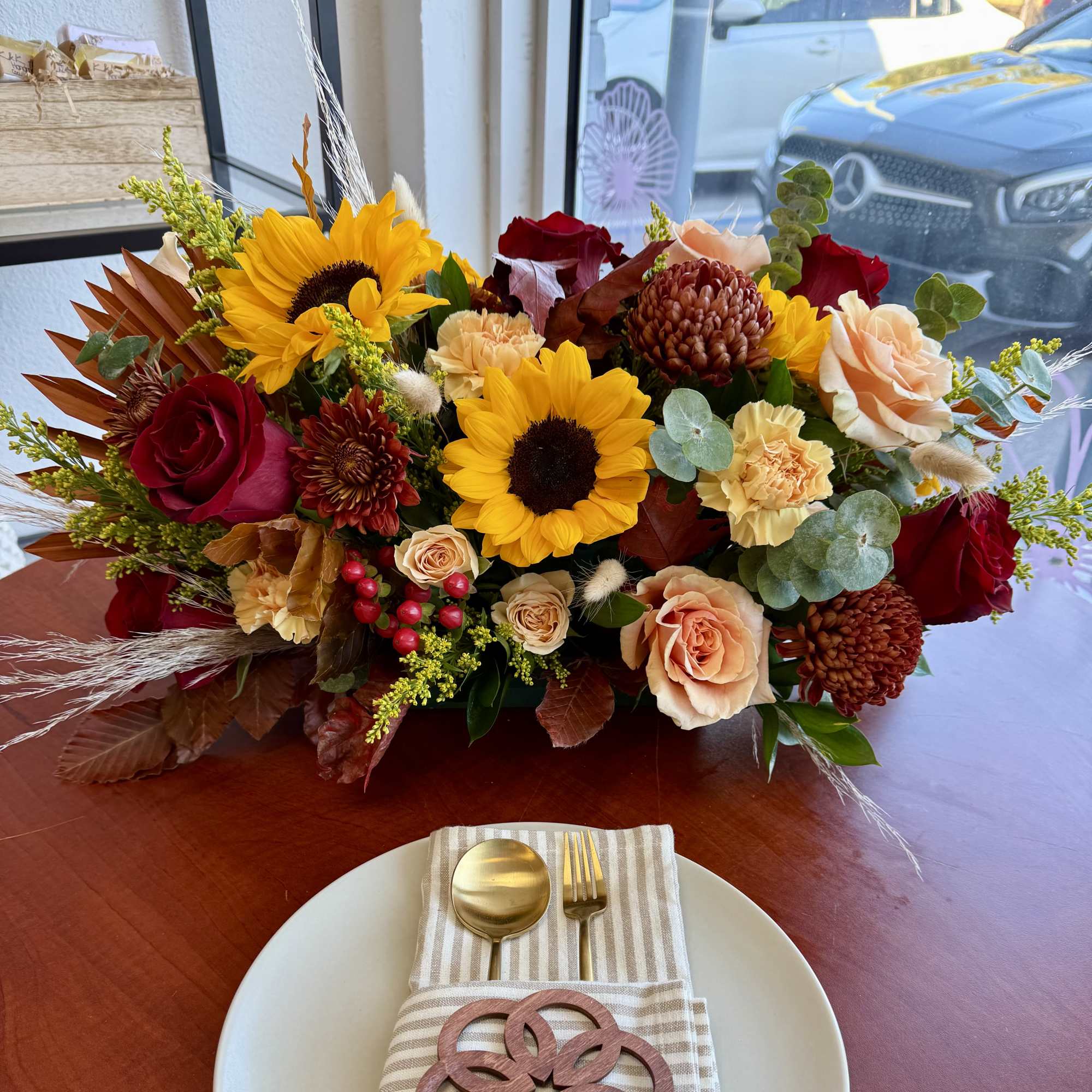 Mixed bouquet with sunflowers, roses, and chrysanthemums on a table