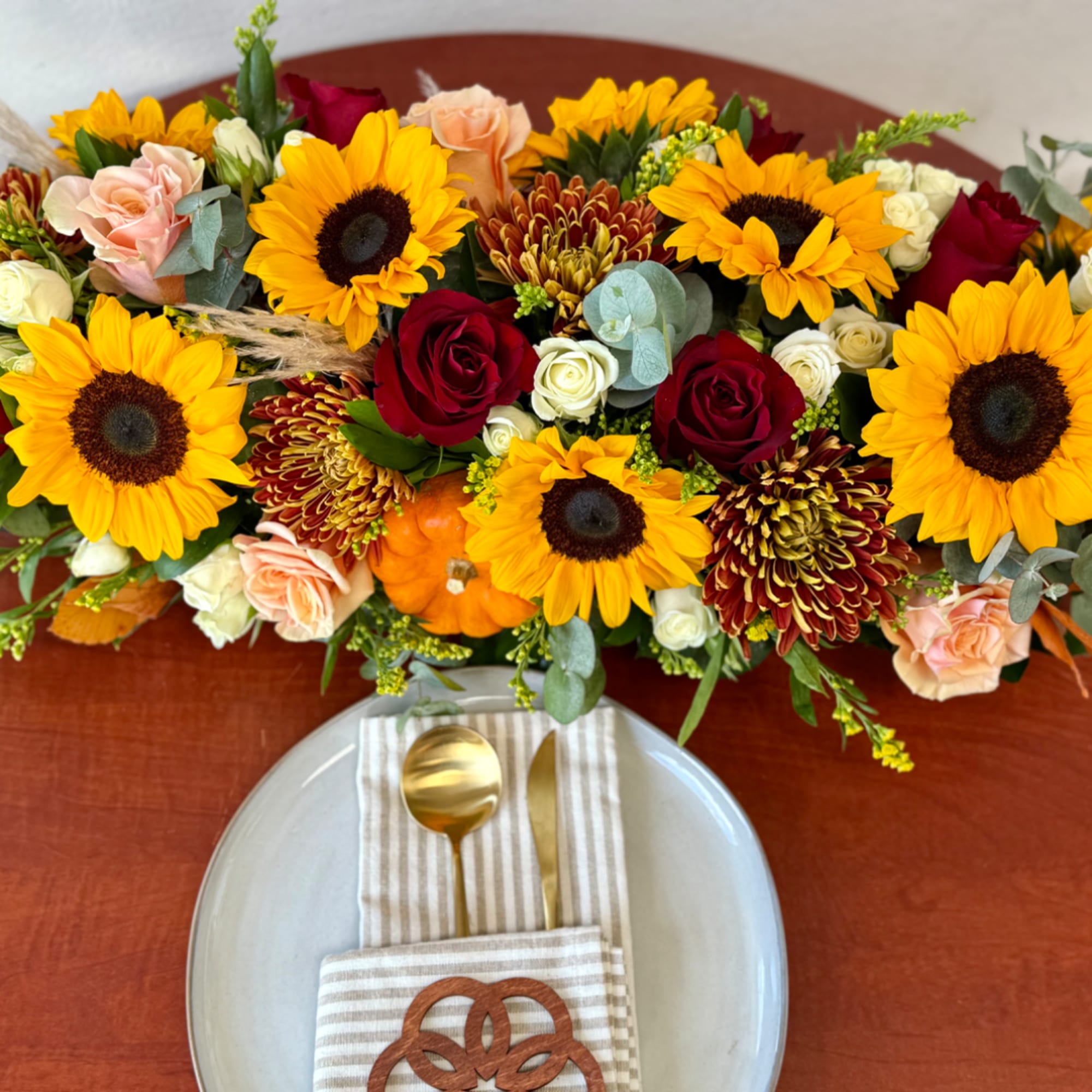 Mixed bouquet with sunflowers, roses, and chrysanthemums on a table setting