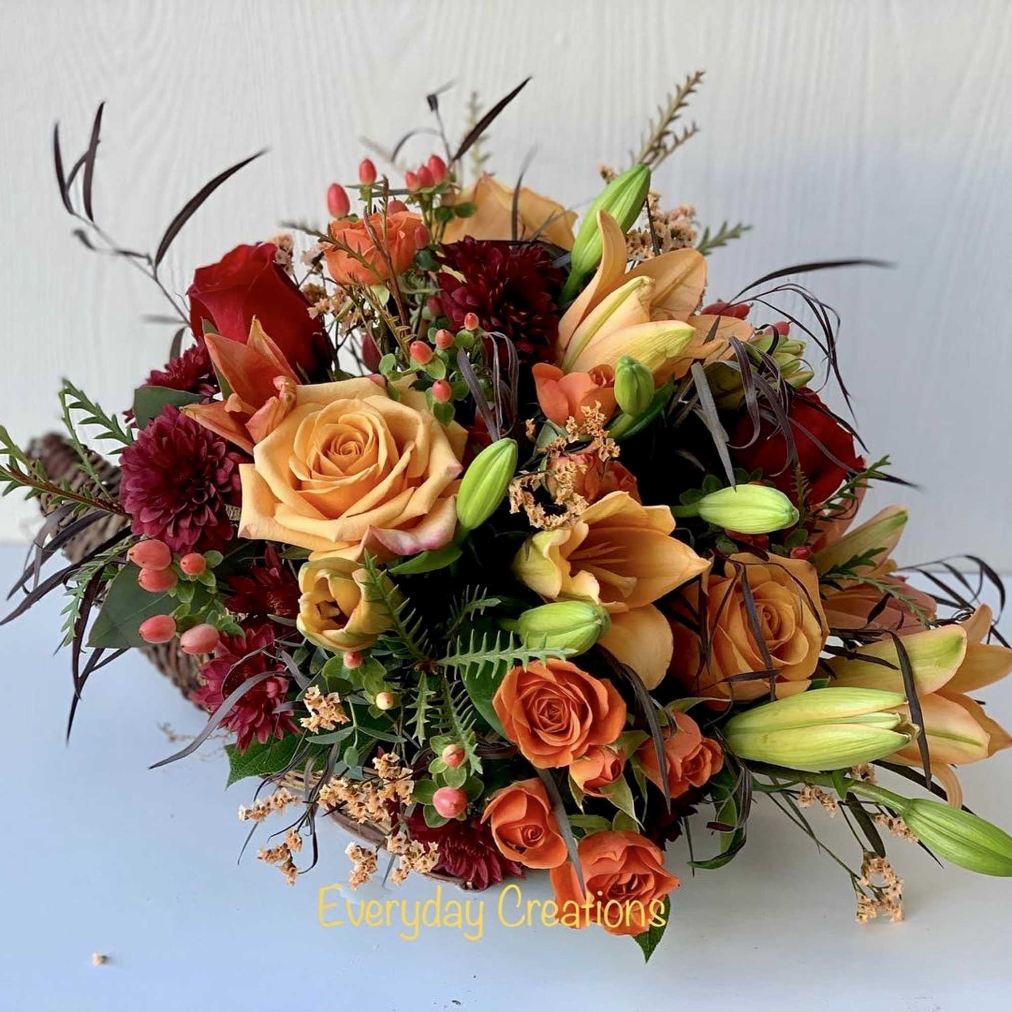 Mixed bouquet with orange and red roses in a basket