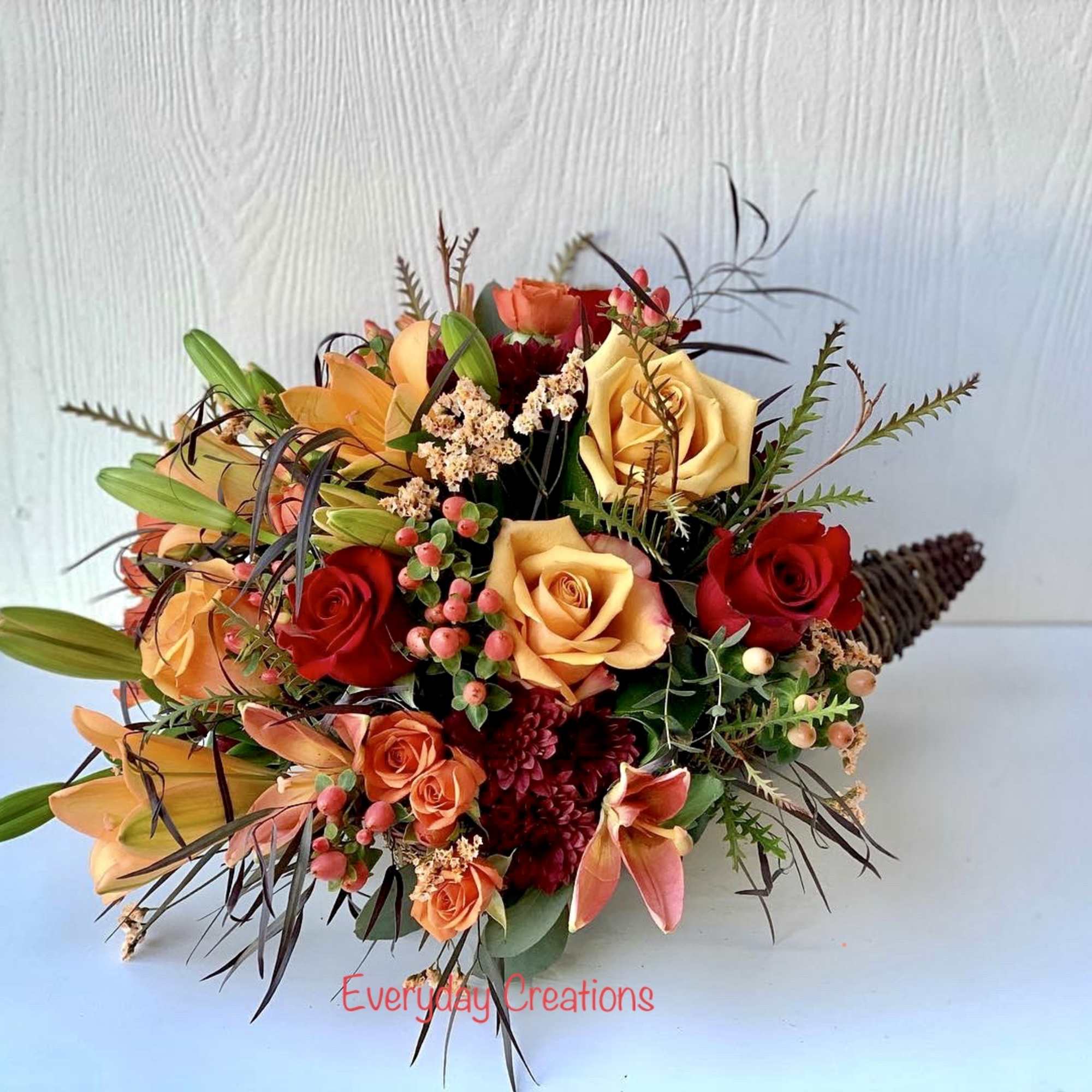 Mixed bouquet of red, peach, and yellow roses with lilies