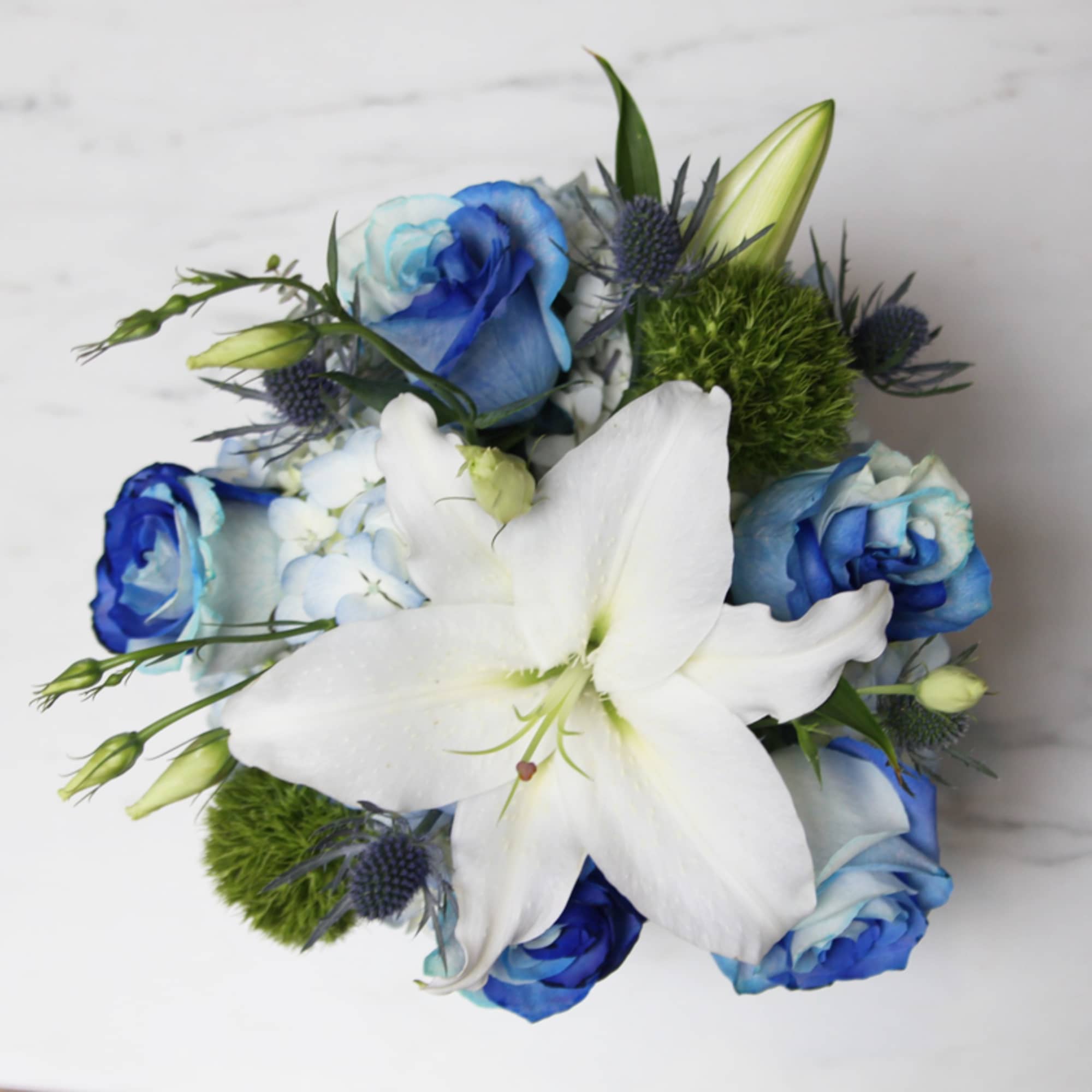 Blue and white bouquet with a large white lily and roses