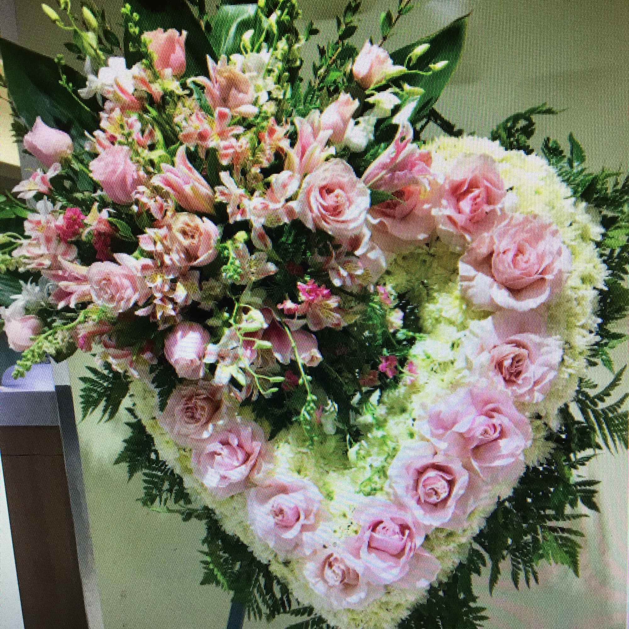 Heart-shaped pink and white floral wreath on an easel