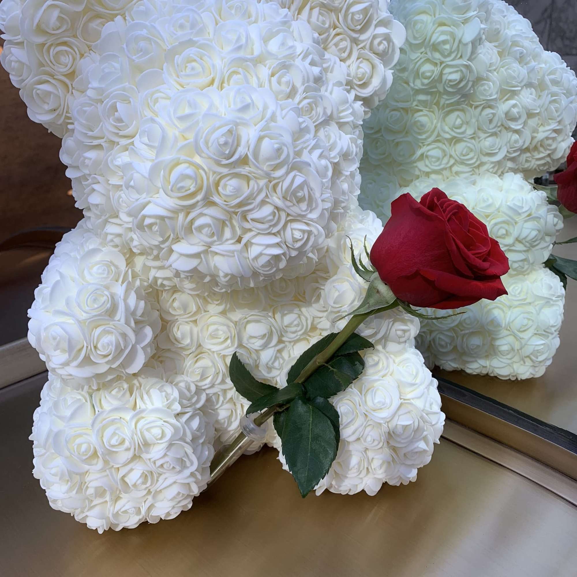 White rose-shaped teddy bears with a single red rose in front