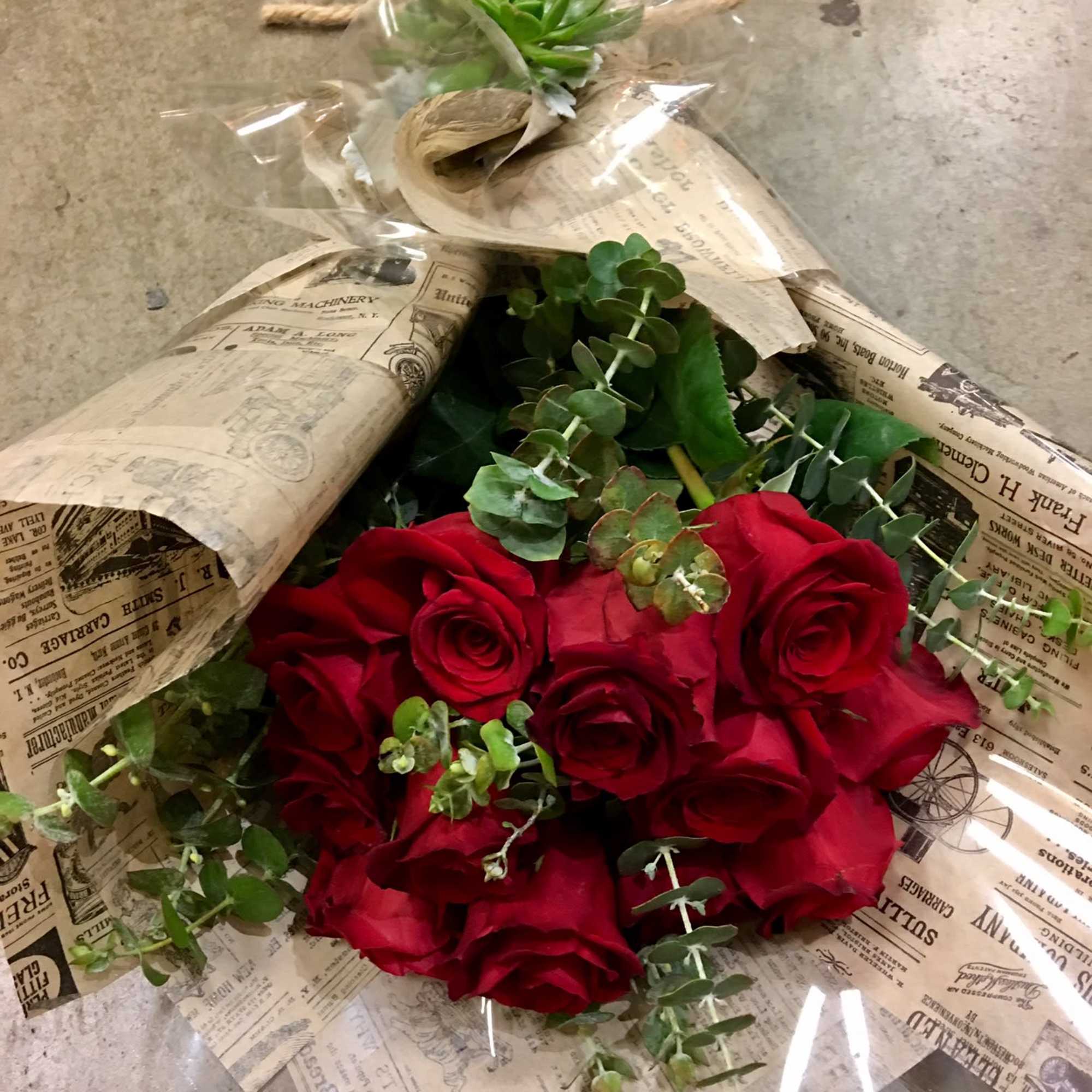 Bouquet of red roses wrapped in newspaper-style paper