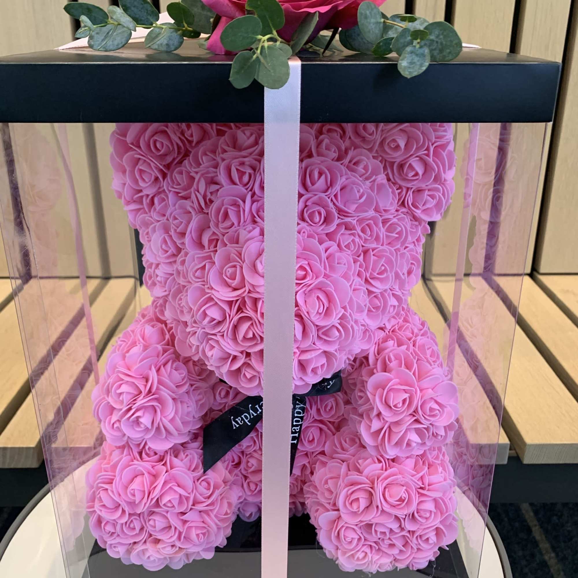 Pink rose teddy bear in a clear gift box with a ribbon