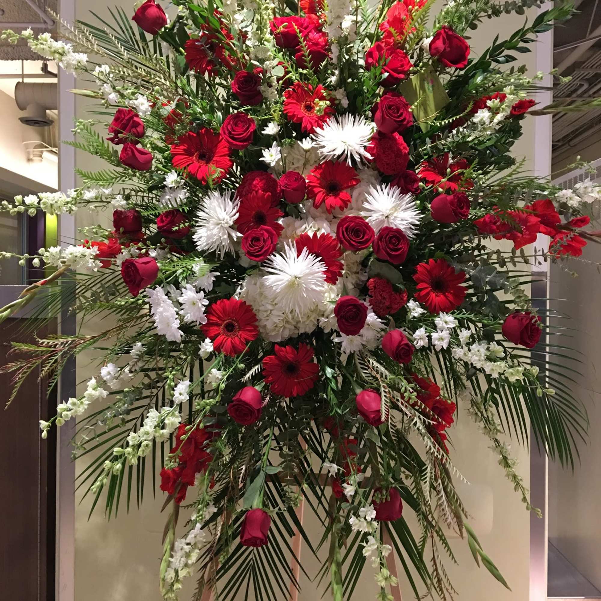 Large standing spray of red and white flowers on an easel