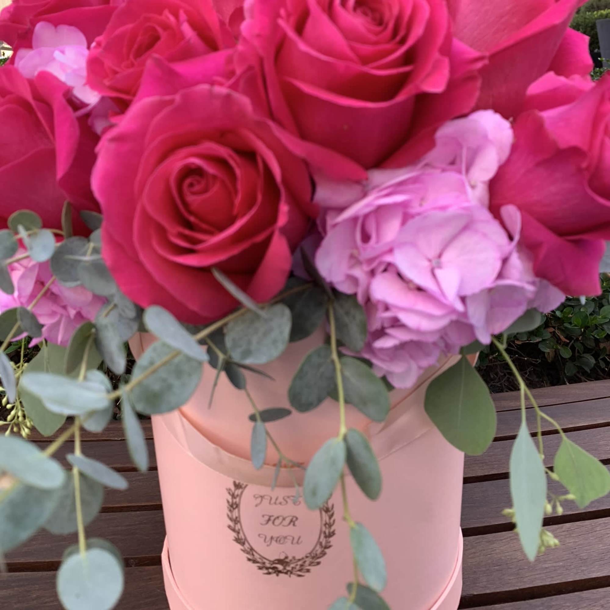 Hot pink roses and pale pink hydrangea in a blush hatbox