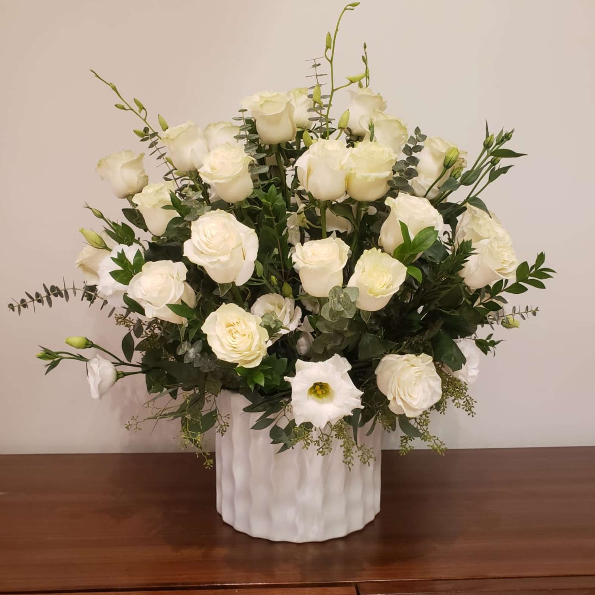 White rose arrangement in a white ceramic vase