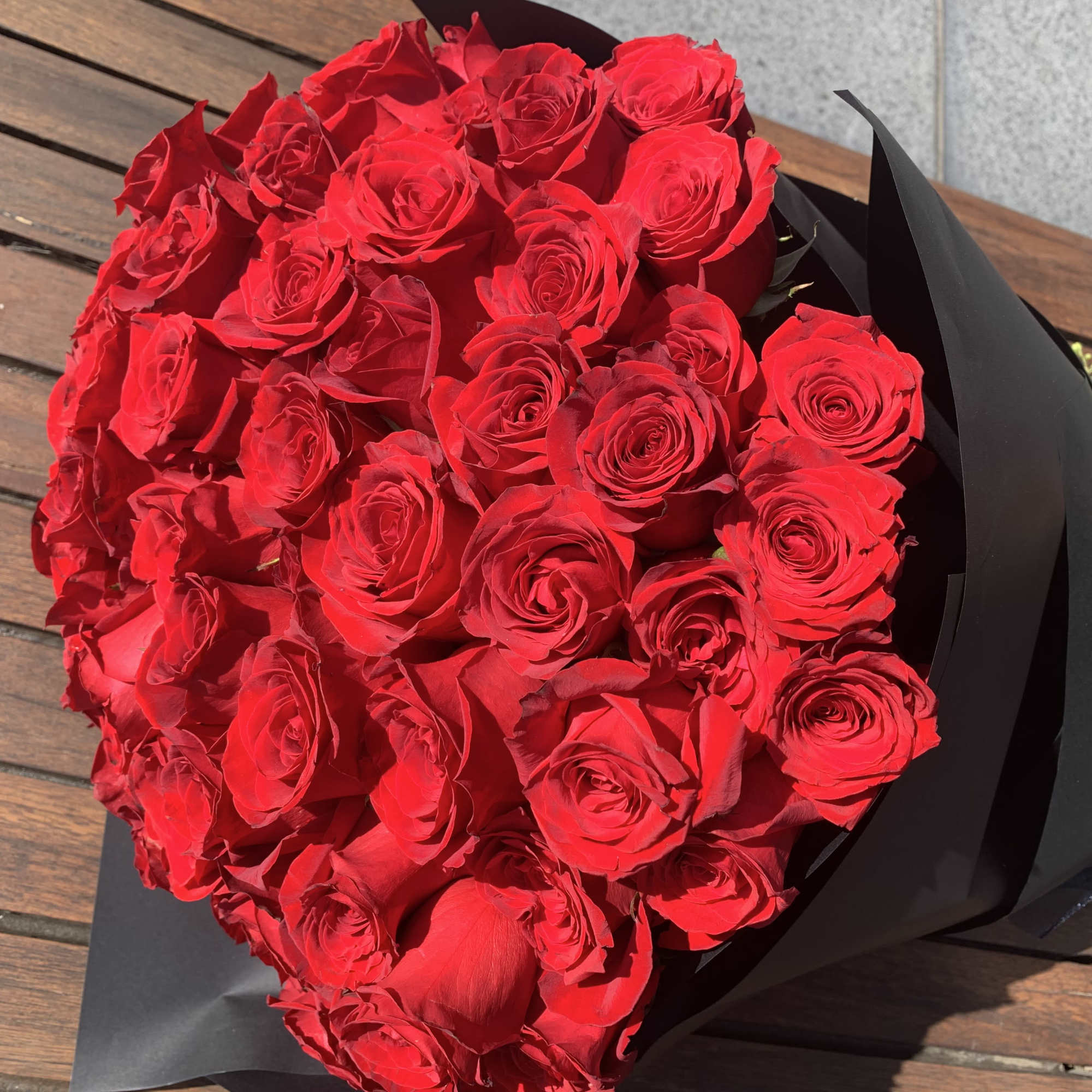 Bouquet of red roses wrapped in black paper