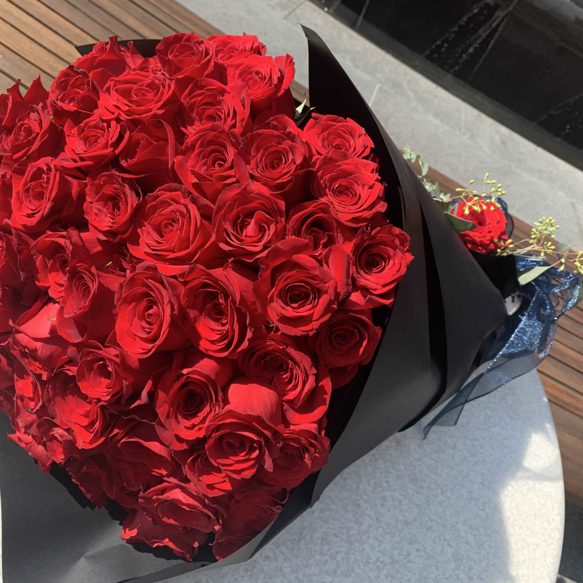 Large bouquet of red roses wrapped in black paper, photo 4 of 5