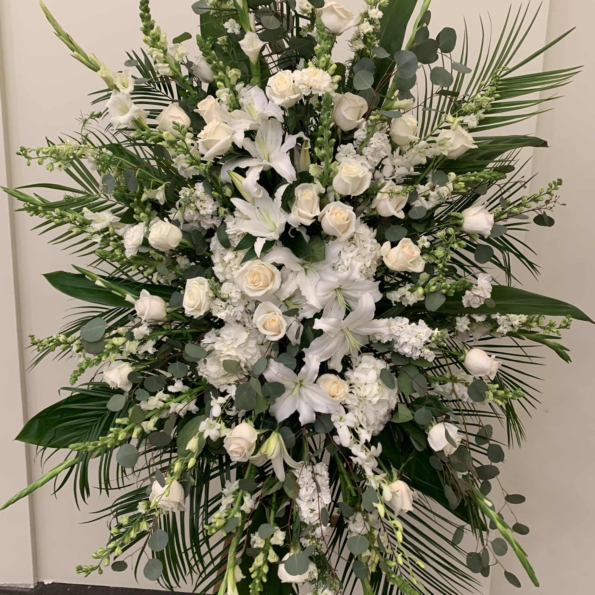 Large white funeral spray with roses and lilies