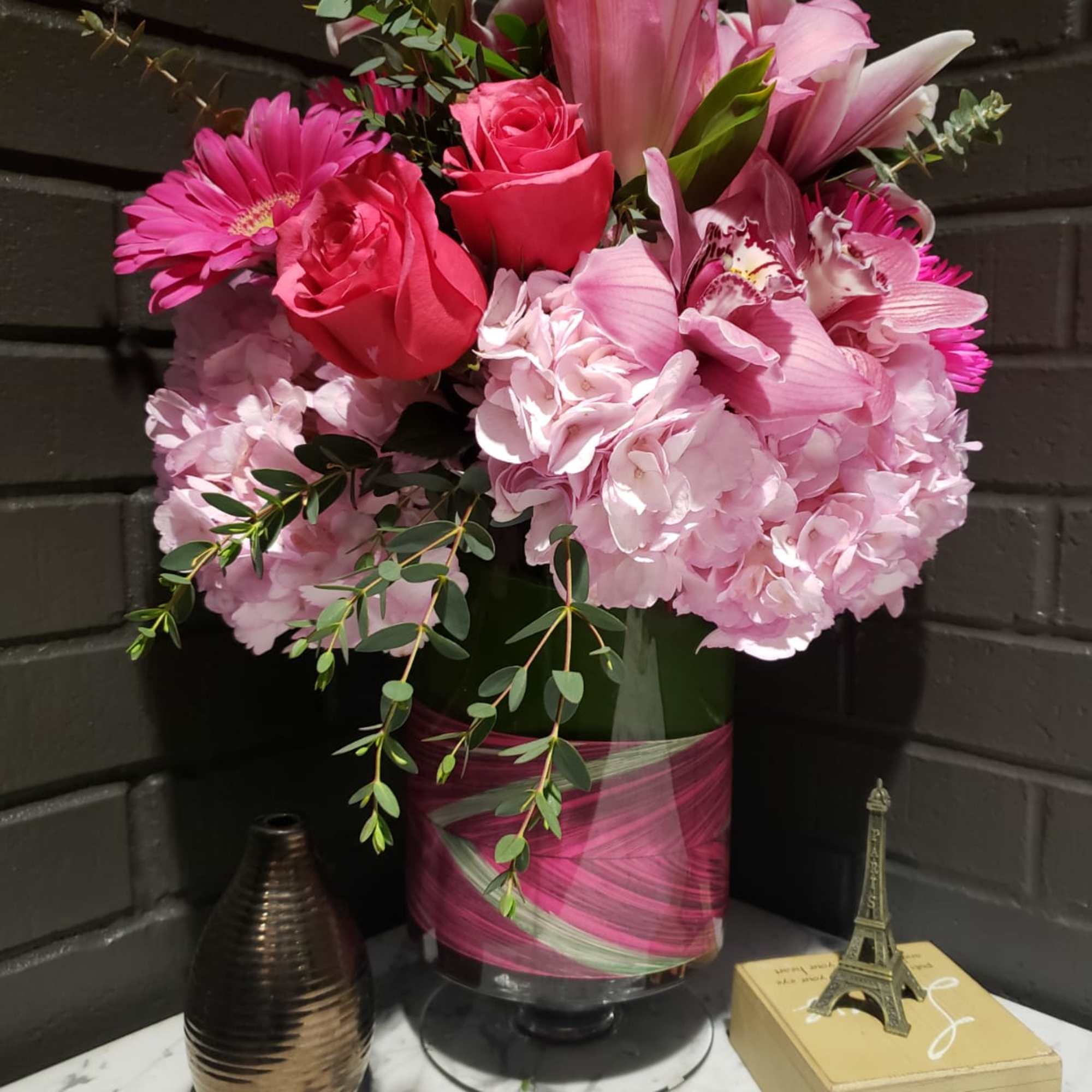 Pink bouquet with roses, lilies, and hydrangeas in a glass vase