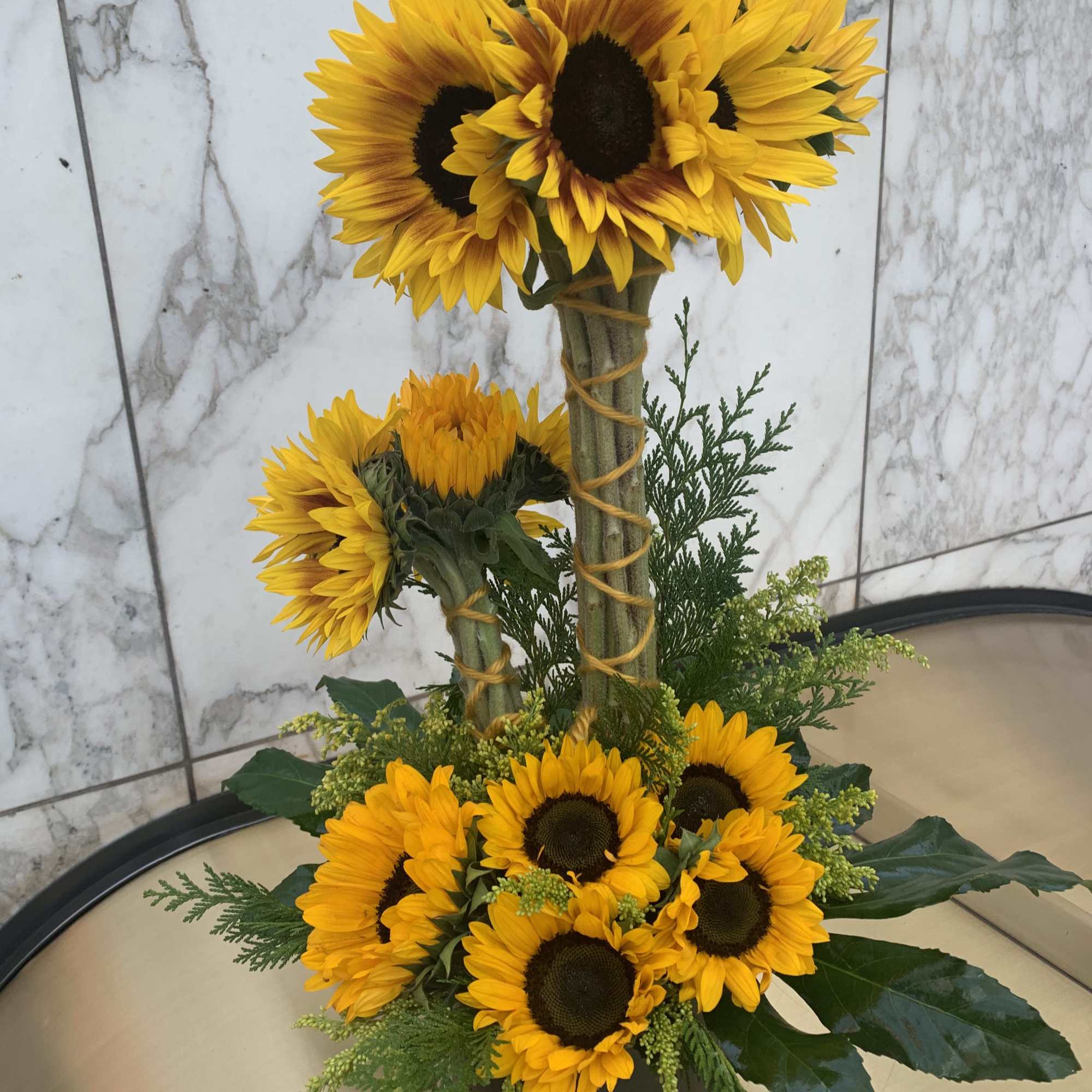 Sunflower arrangement in a white container with two tiers of blooms