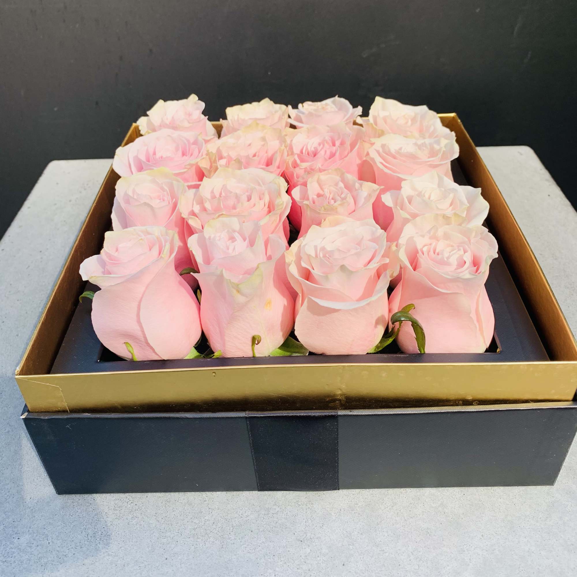 Box of pale pink roses arranged in a black gift box