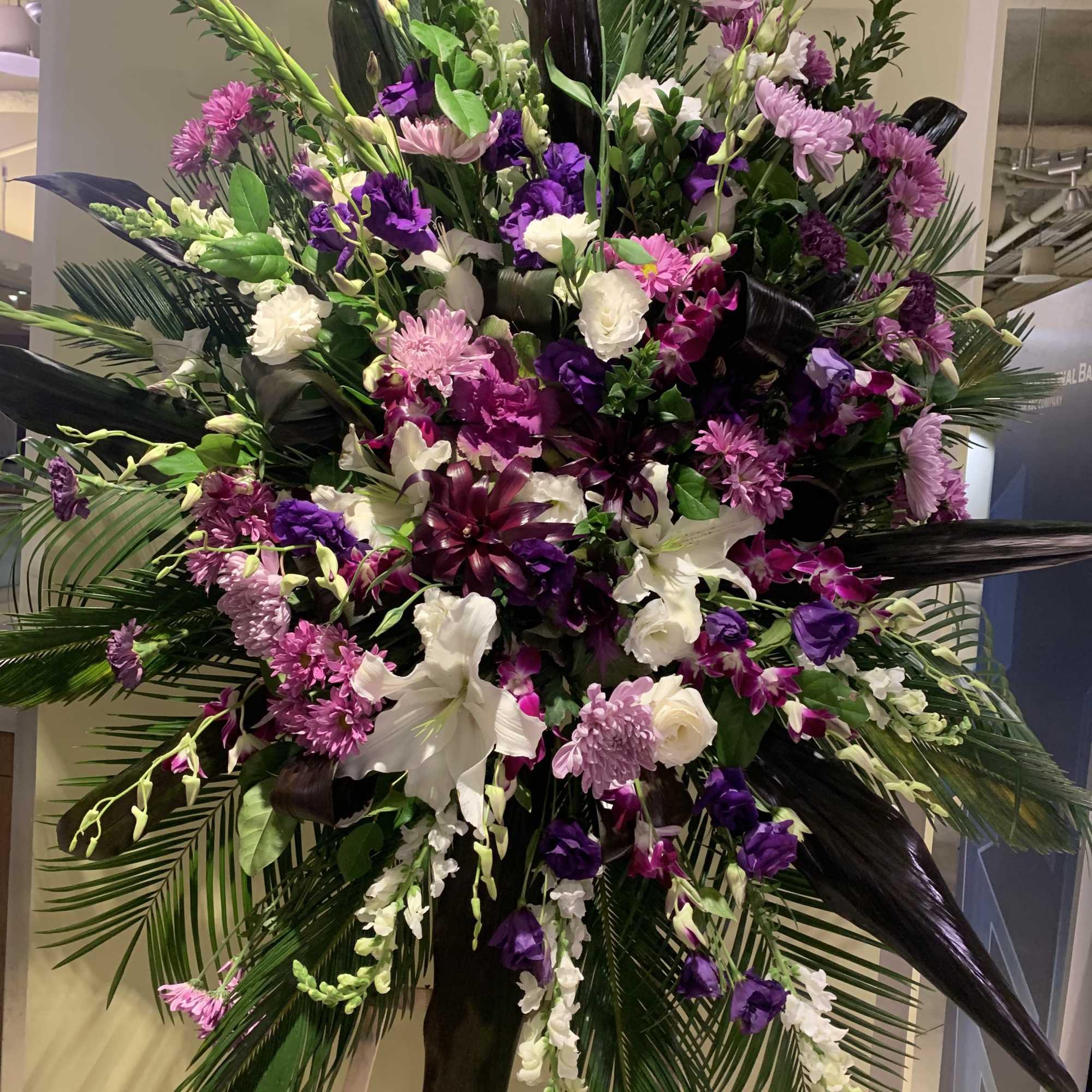 Large standing floral spray with purple, pink, and white flowers