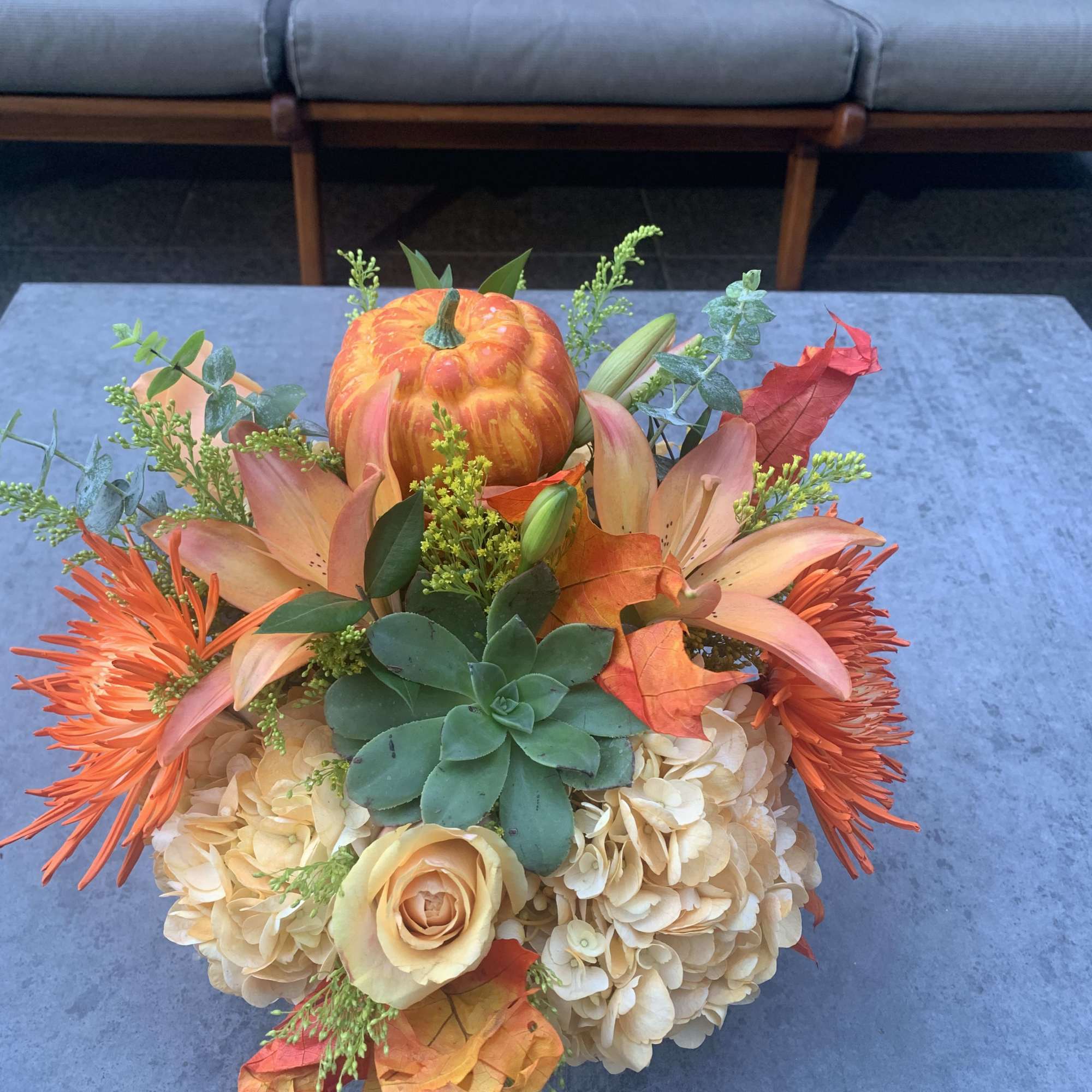 Autumn bouquet with a pumpkin, peach flowers, and succulents