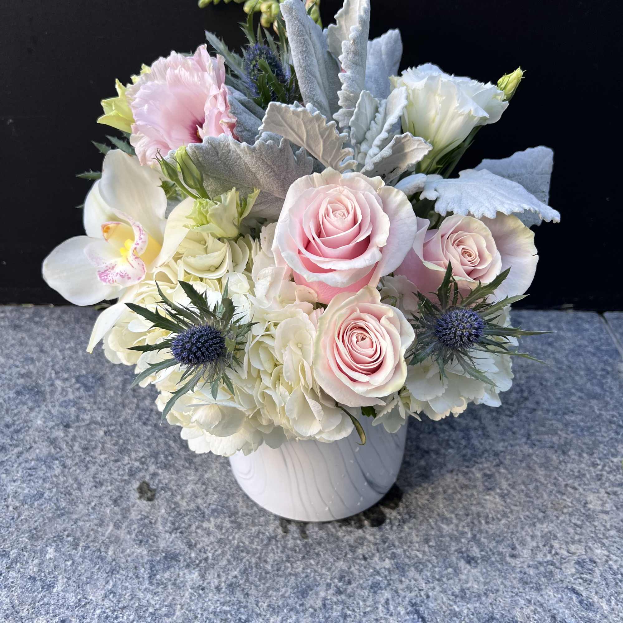 Pink roses and white orchids in a white vase