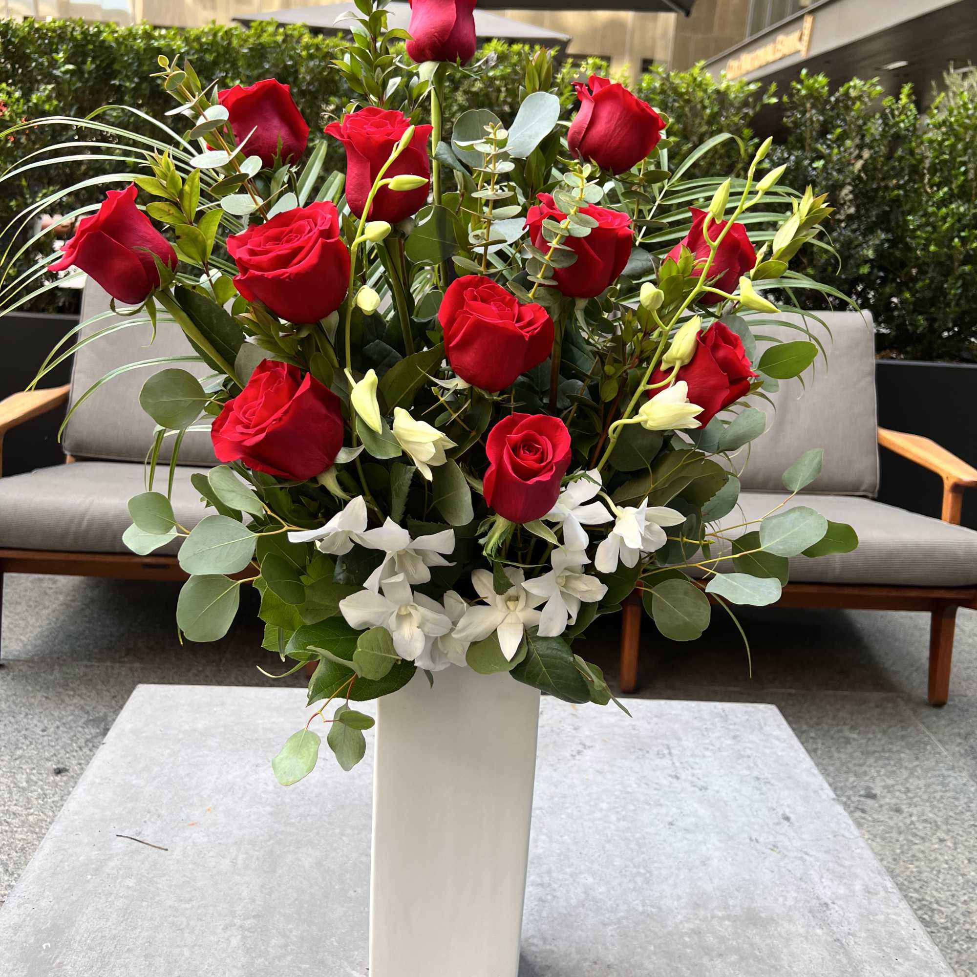 Tall arrangement of red roses and white orchids in a white vase, photo 3 of 7