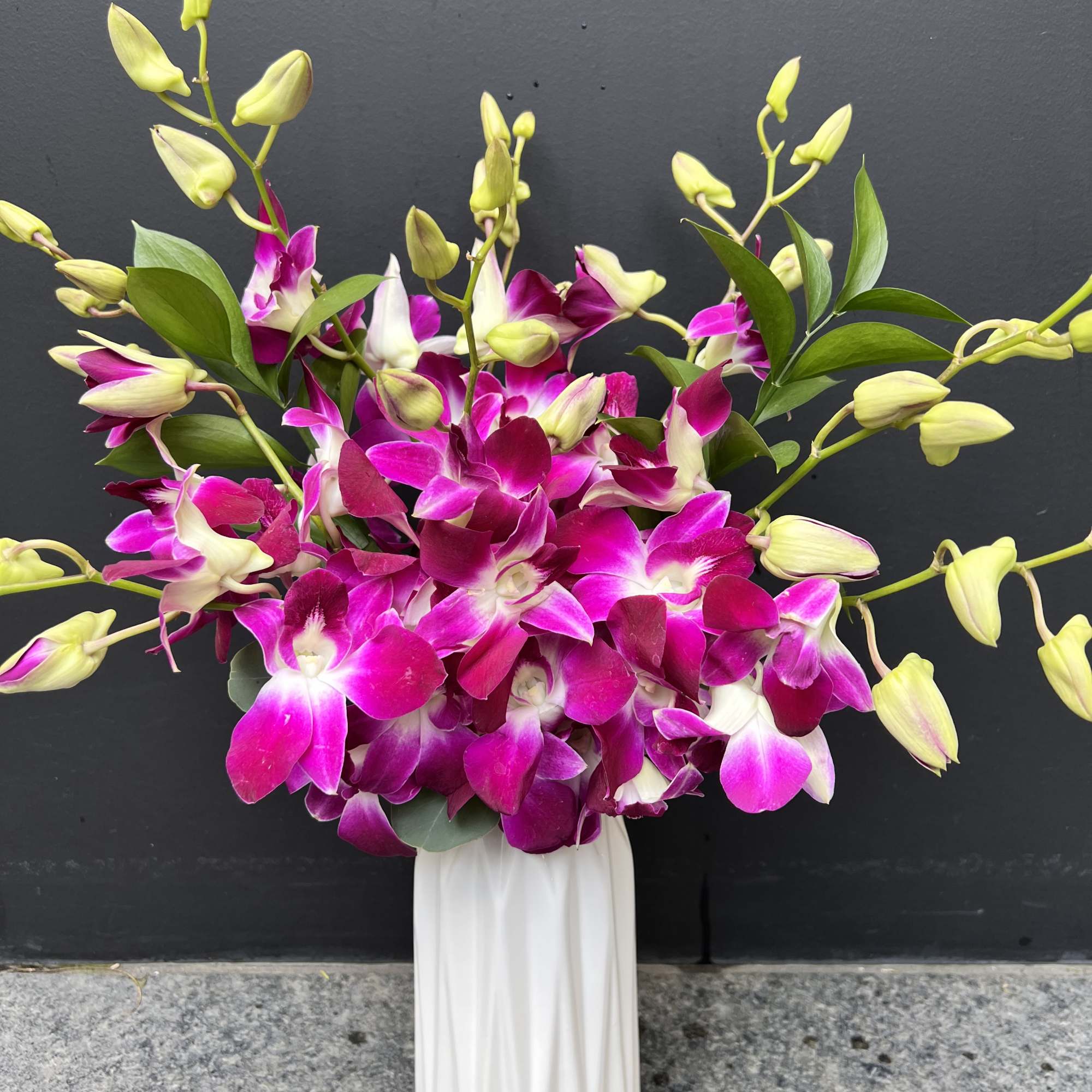 Pink and white orchids arranged in a white vase, photo 2 of 5