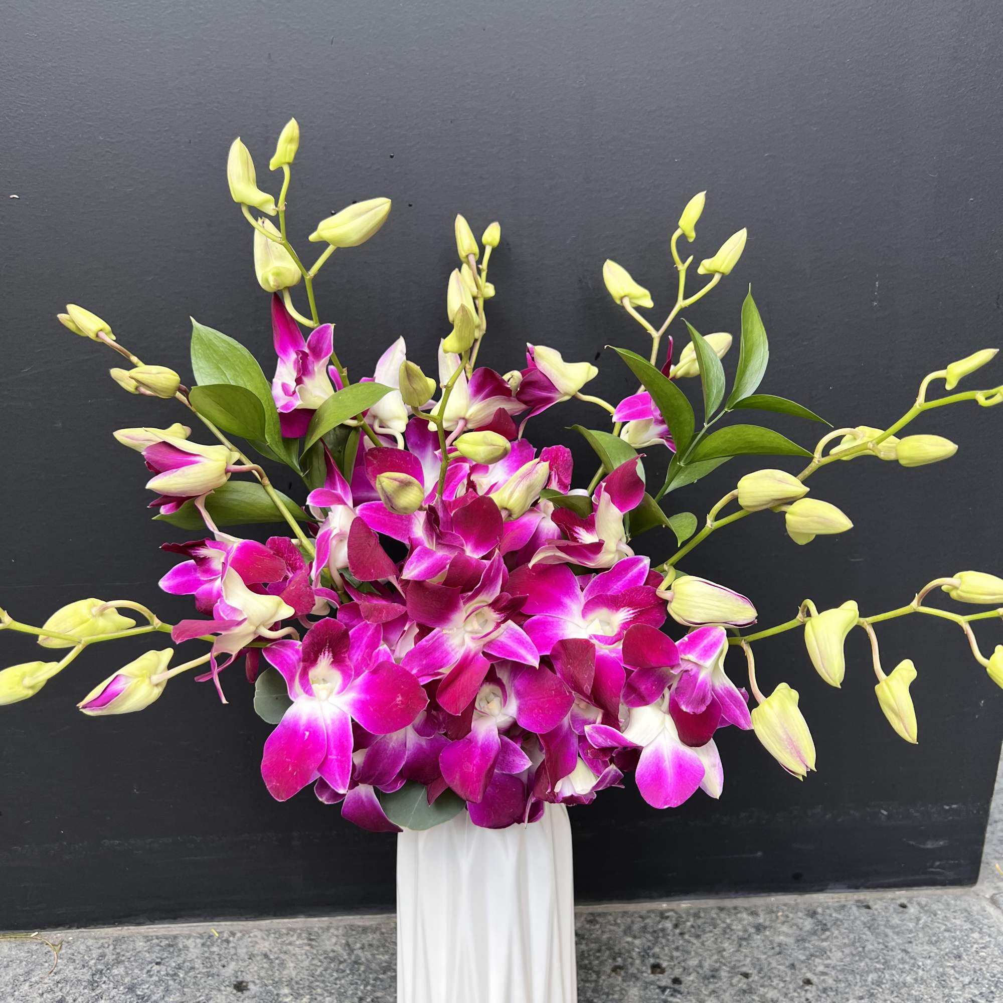 Pink and white orchids arranged in a white vase, photo 5 of 5