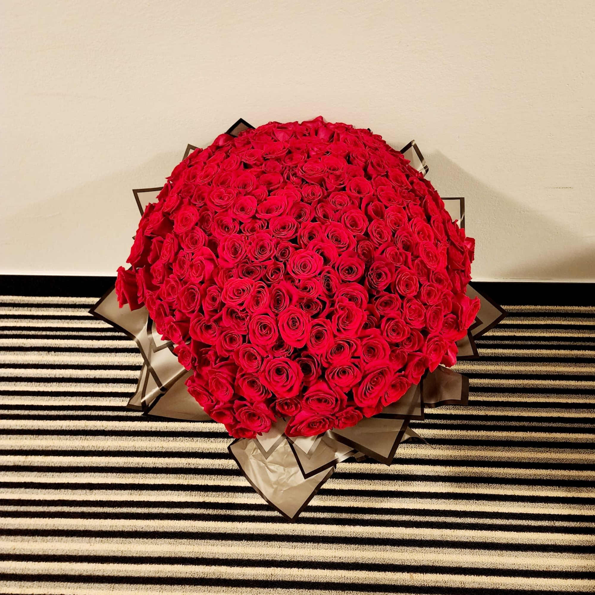 Large bouquet of red roses wrapped in brown paper