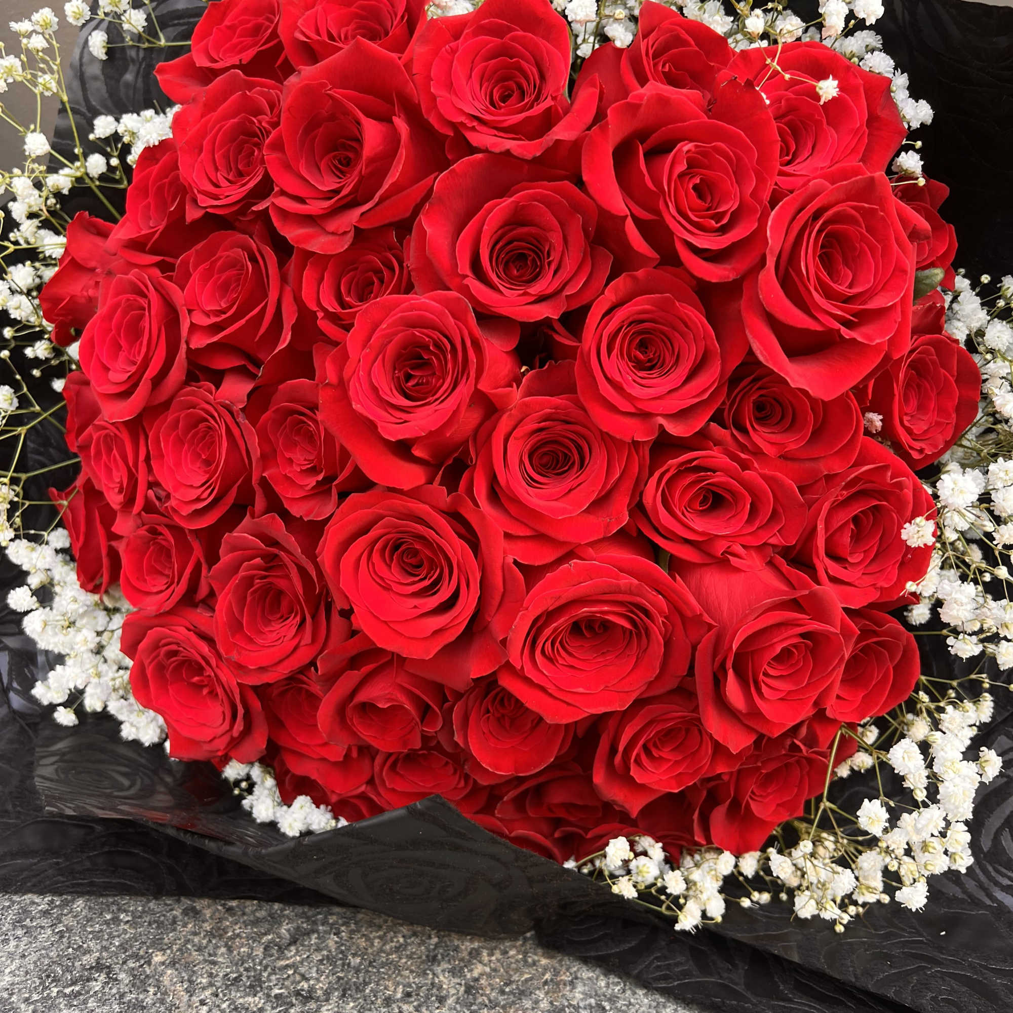 Bouquet of red roses with white baby's breath in black wrap, photo 3 of 3