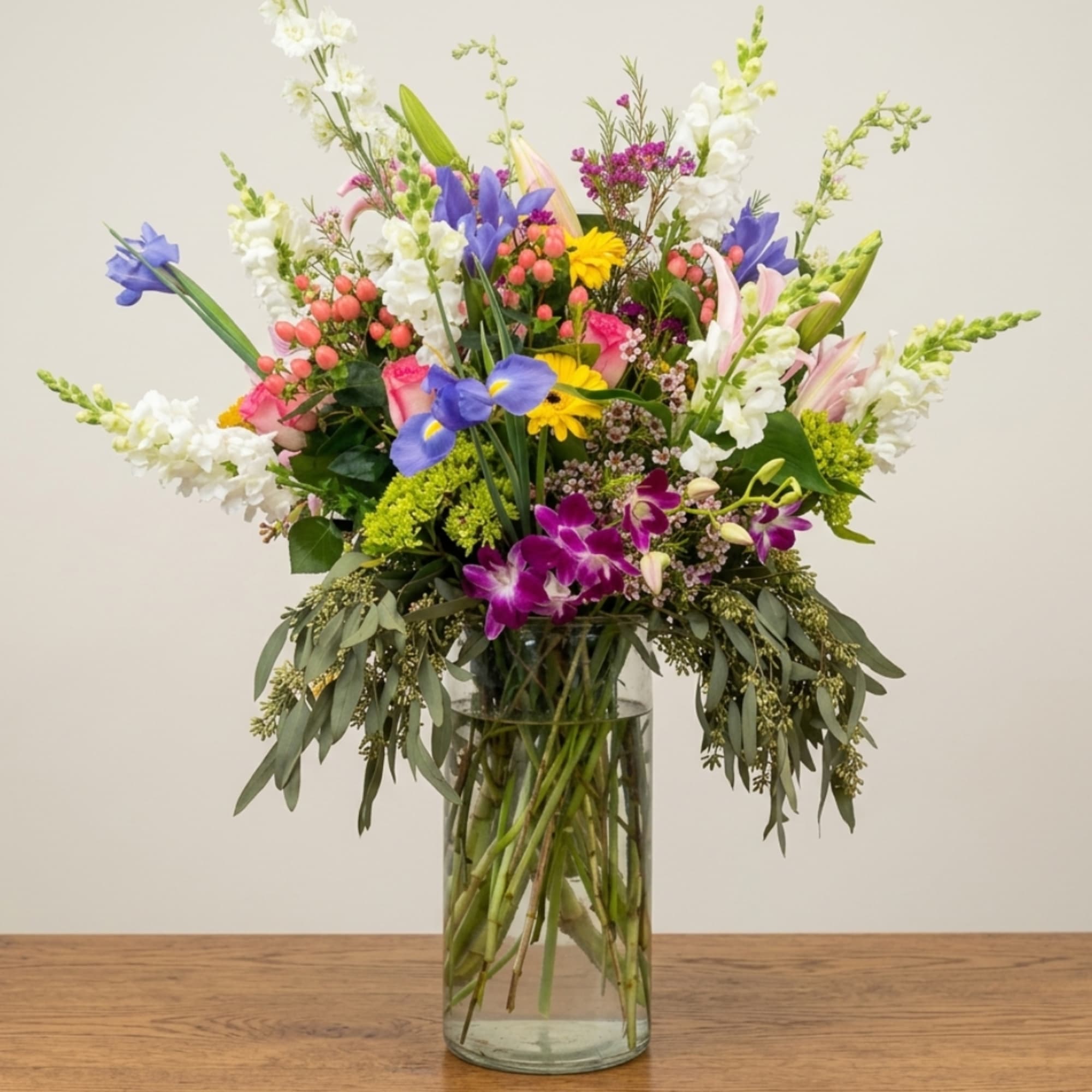 Mixed bouquet of colorful flowers in a clear glass vase