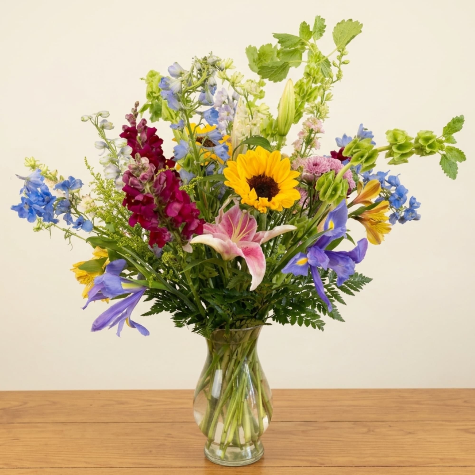 Mixed bouquet of colorful flowers in a clear glass vase