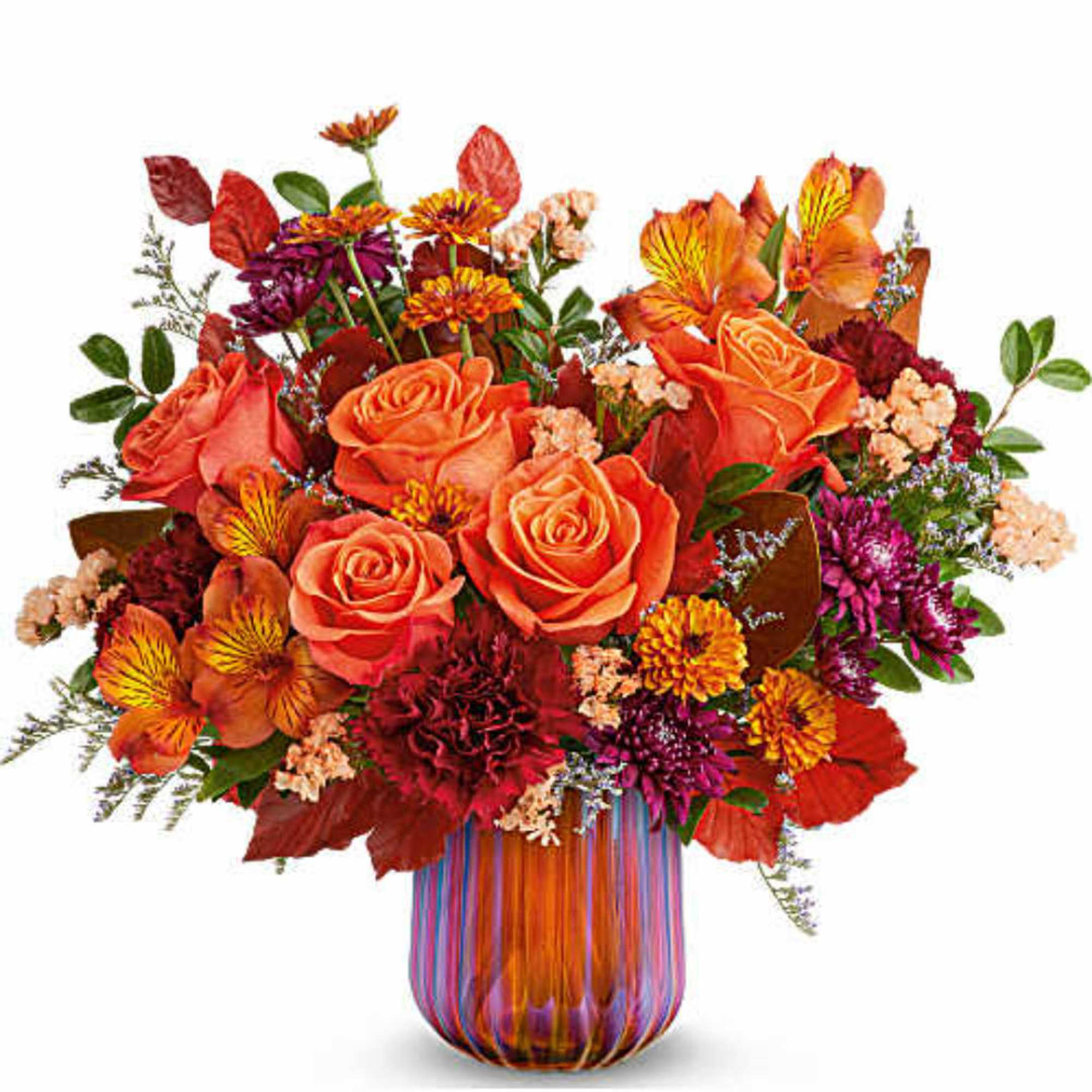 Orange roses and mixed fall flowers in a striped glass vase