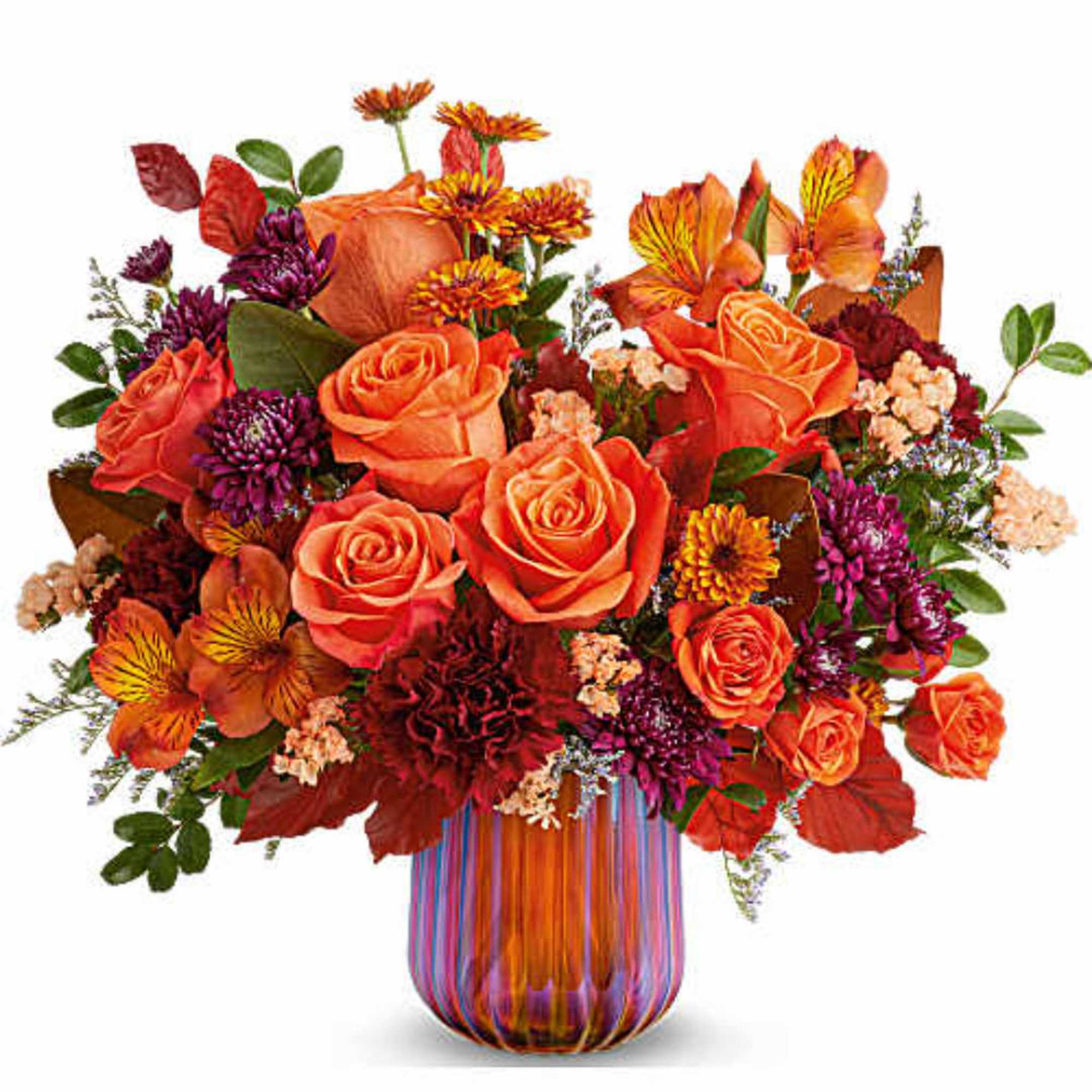 Orange roses and mixed fall flowers in a striped glass vase