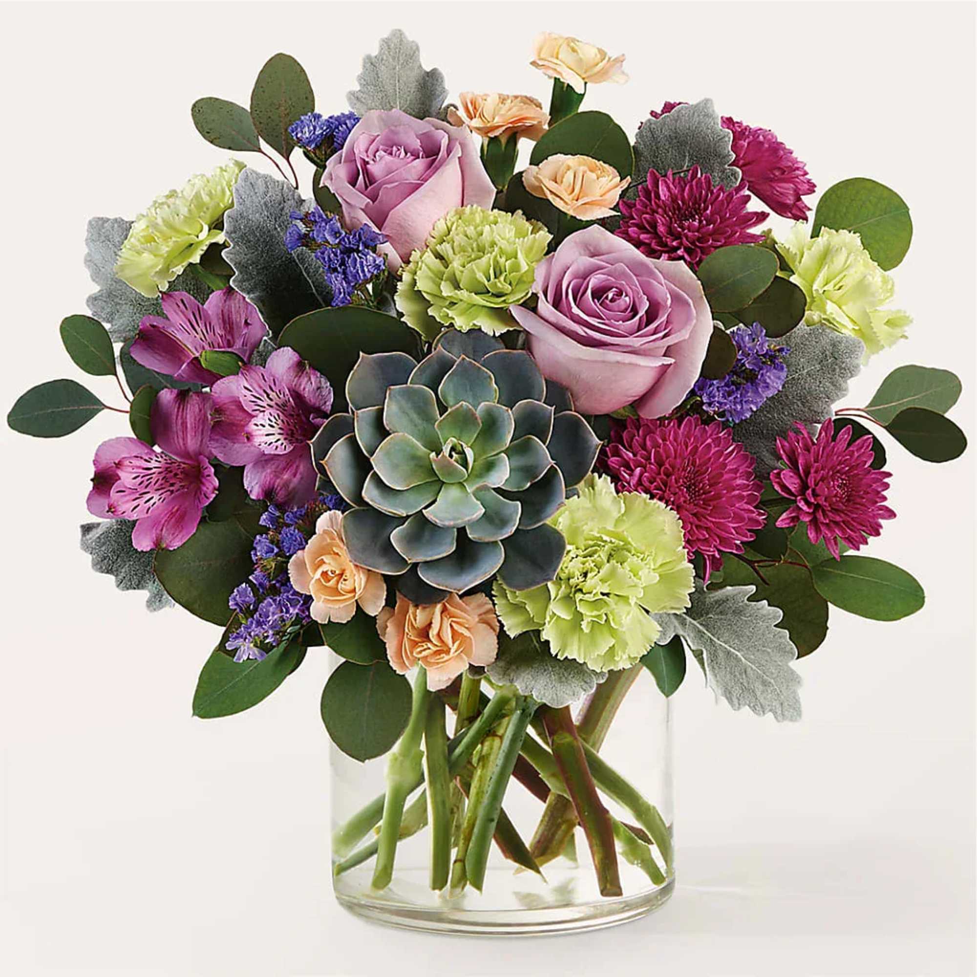 Mixed bouquet with roses, carnations, and a succulent in a glass vase