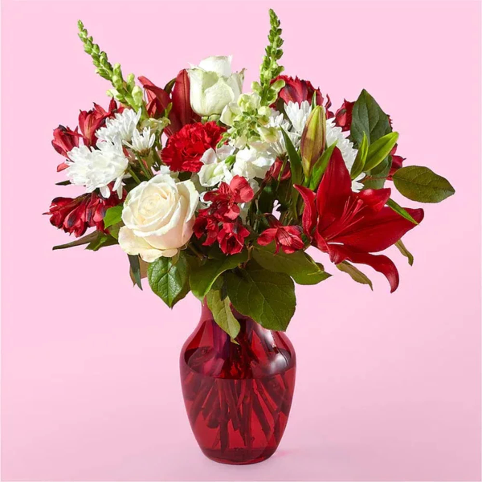 Bouquet of red and white flowers in a red glass vase
