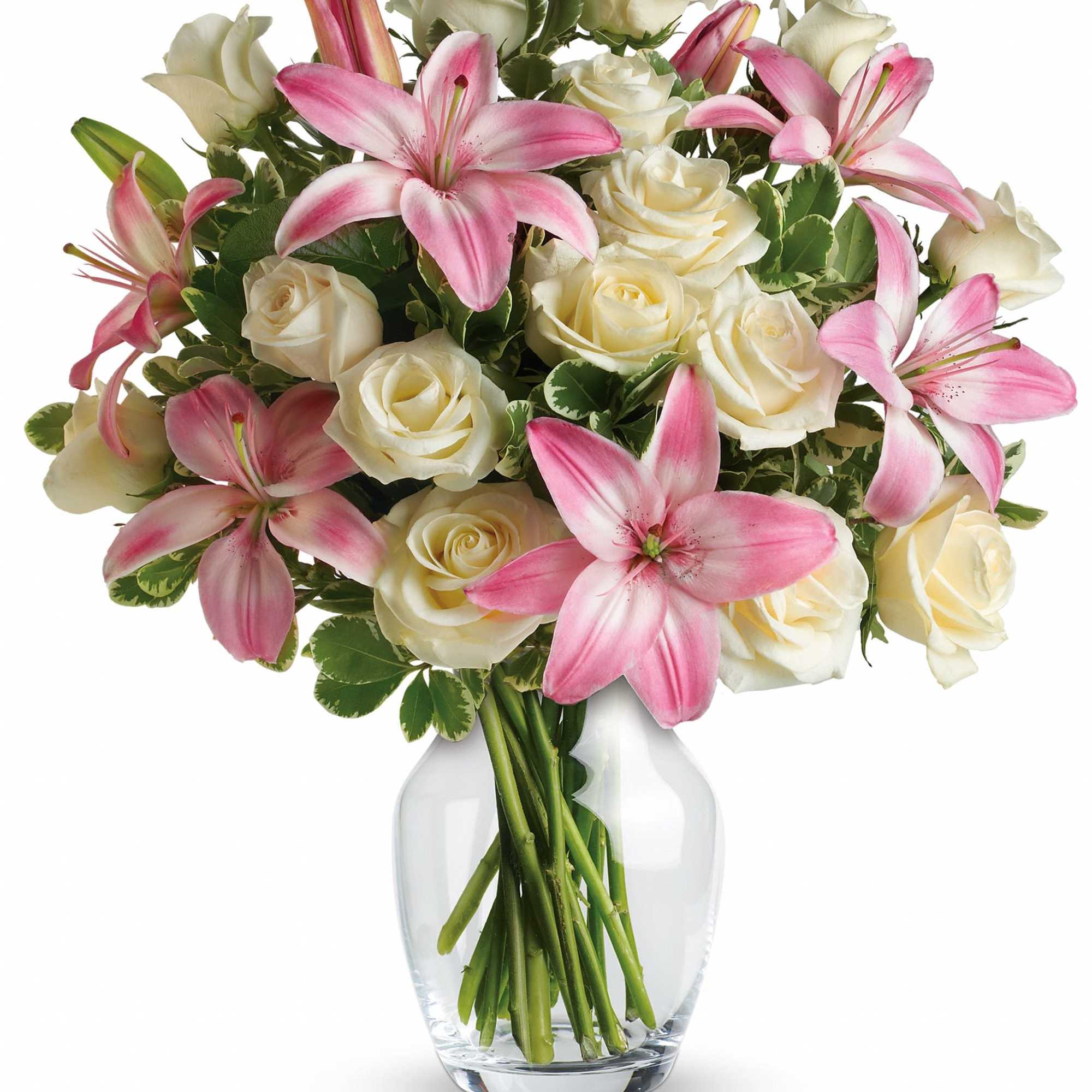 Pink lilies and white roses arranged in a clear glass vase