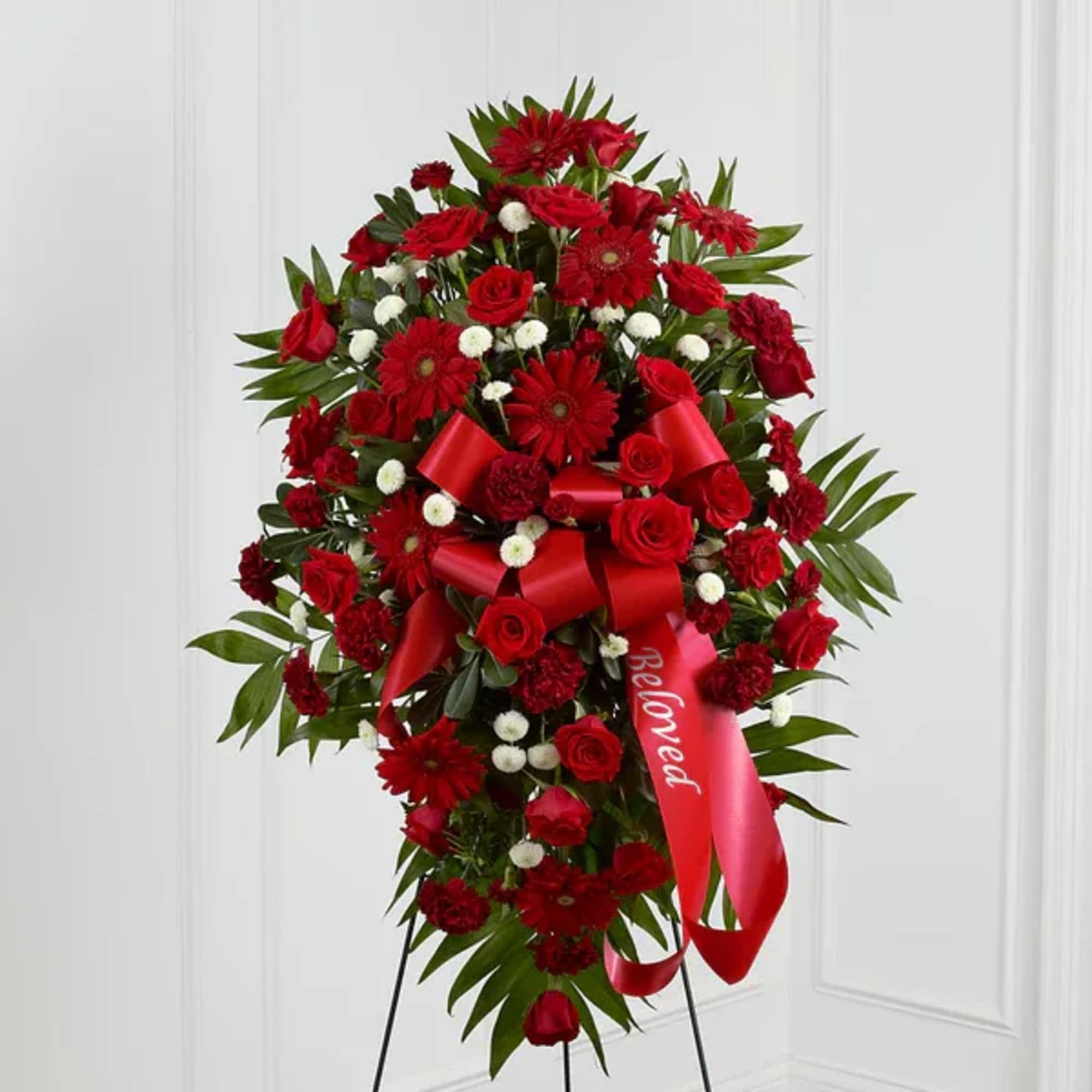 Red floral standing spray with a red ribbon on an easel